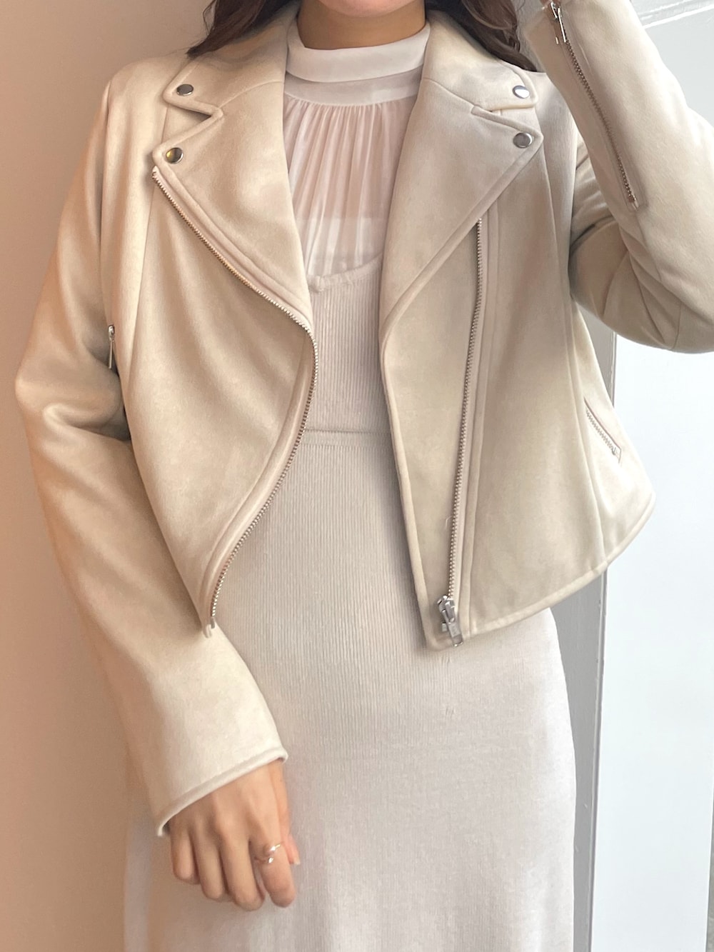 ホワイト系のワンピース、ベージュ系のライダースジャケットを着用したレディースの冬コーディネートの3枚目の写真