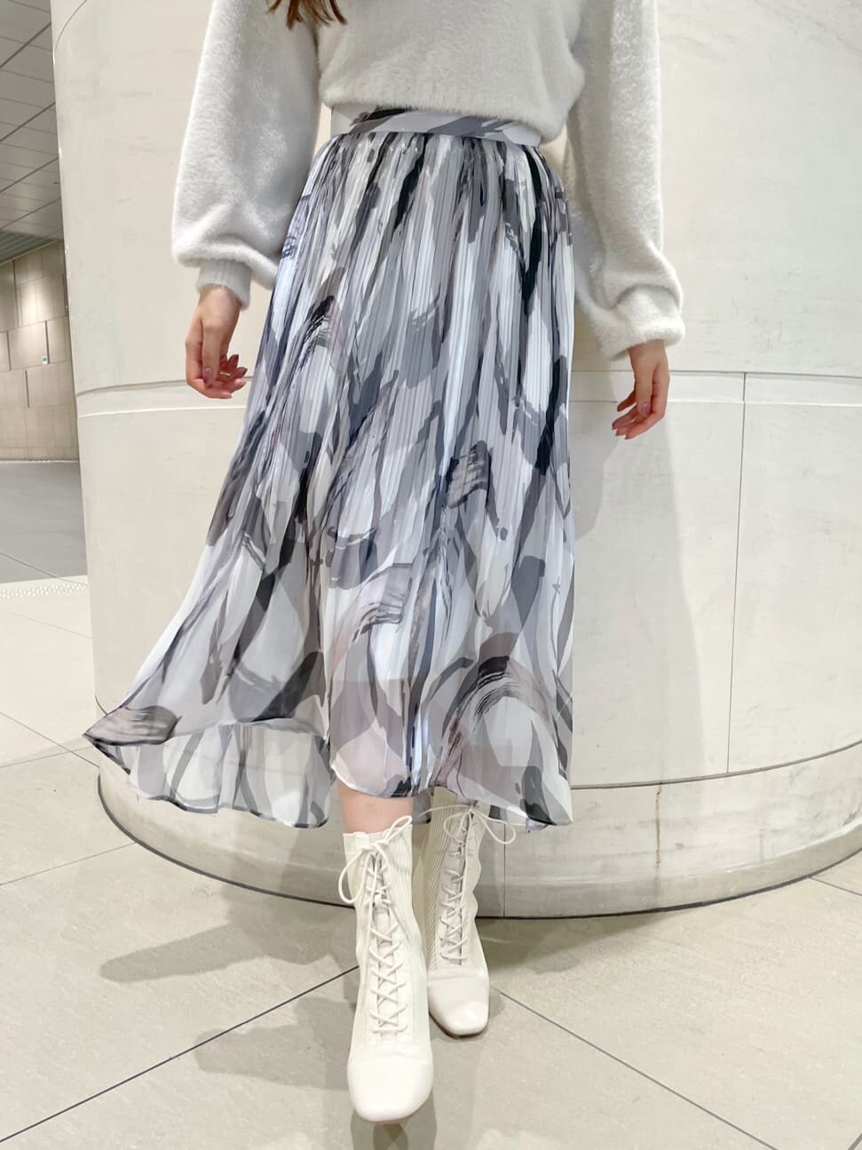 ブラウン系のその他アウター、グレー系のスカート、ホワイト系のニット/セーターを着用したレディースの秋コーディネートの8枚目の写真