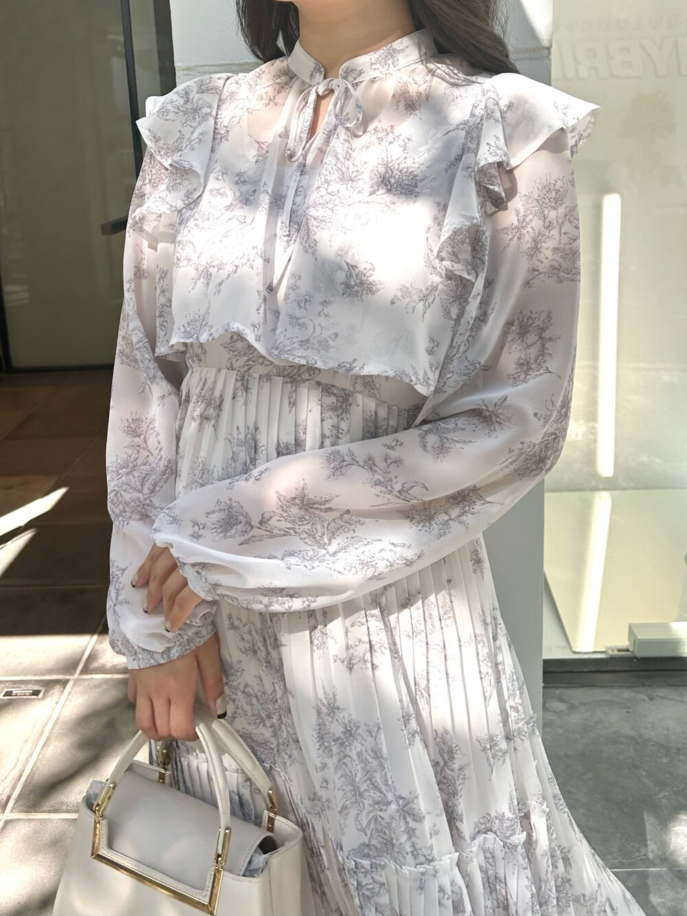 ホワイト系のハンドバッグ、ピンク系のワンピースを着用したレディースの秋コーディネートの4枚目の写真