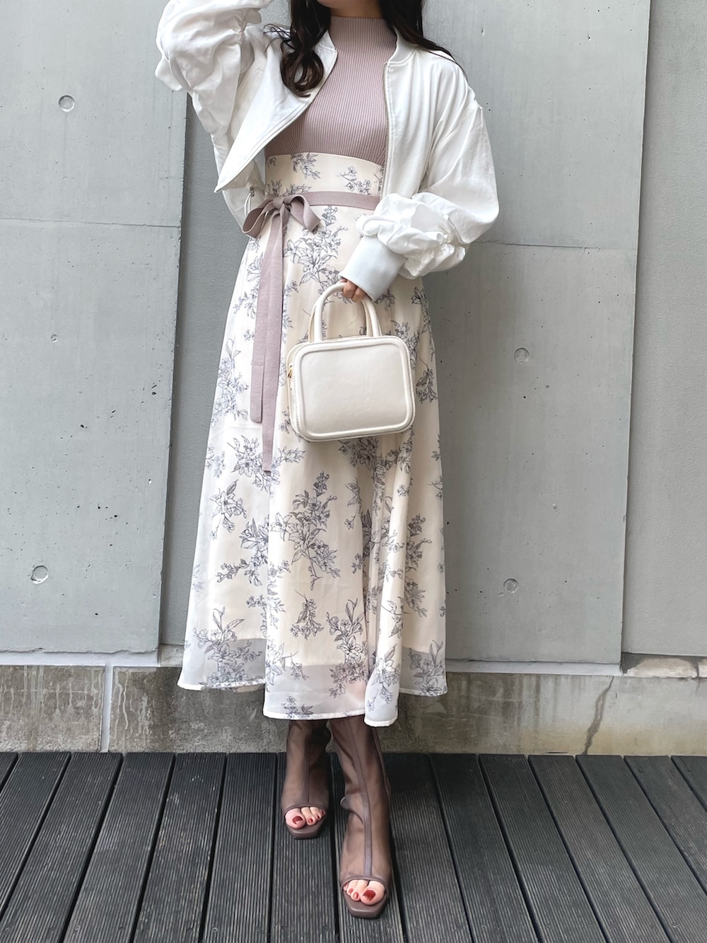 ブラック系のブーツ、ブラック系のハンドバッグ、ホワイト系のワンピースを着用したレディースの春コーディネートの4枚目の写真