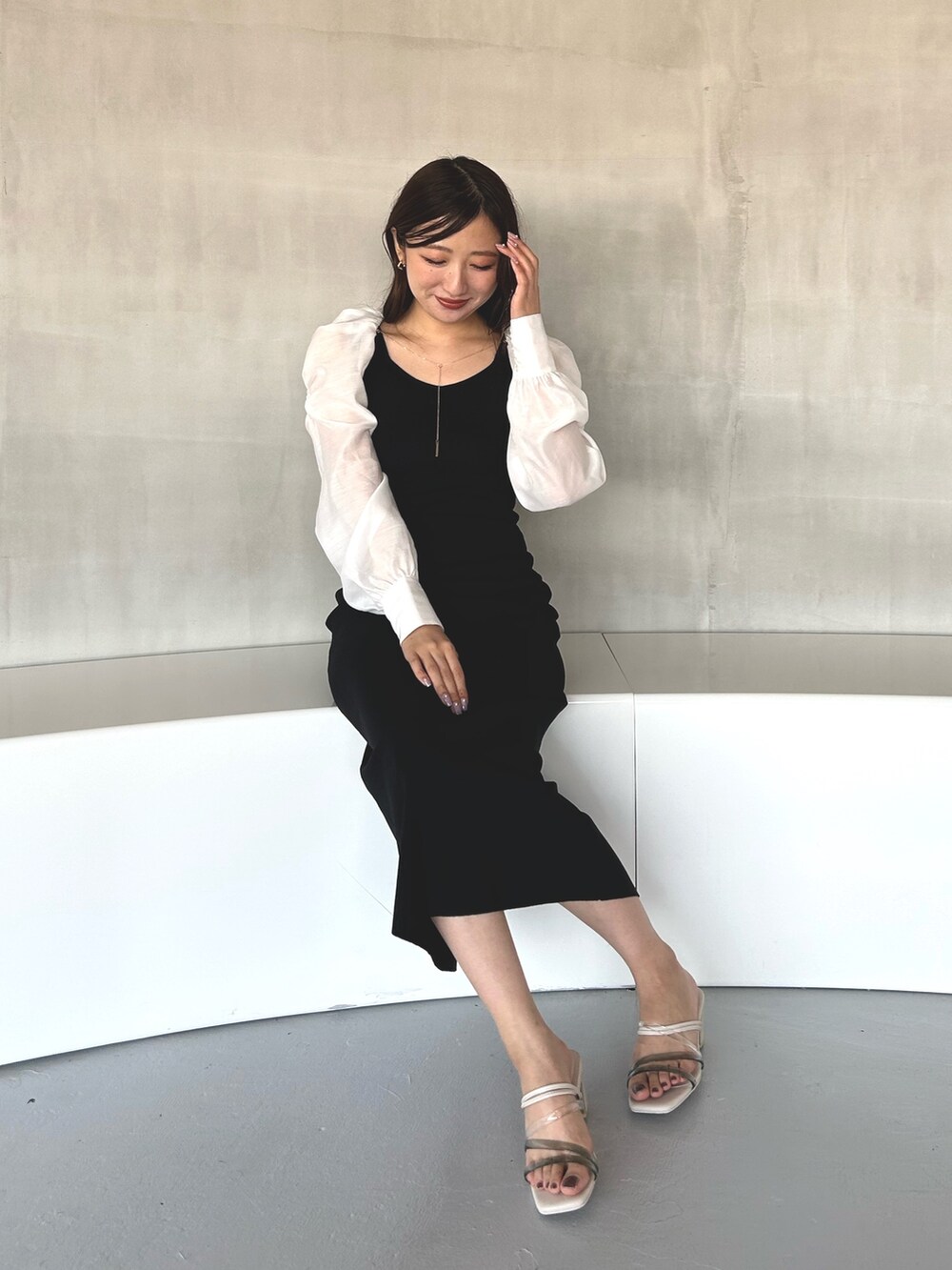 ブラック系のワンピース、ホワイト系のサンダルを着用したレディースの冬コーディネートの7枚目の写真