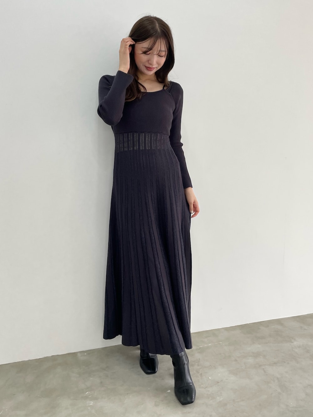 グレー系のワンピース、ホワイト系のトレンチコートを着用したレディースの冬コーディネートの2枚目の写真