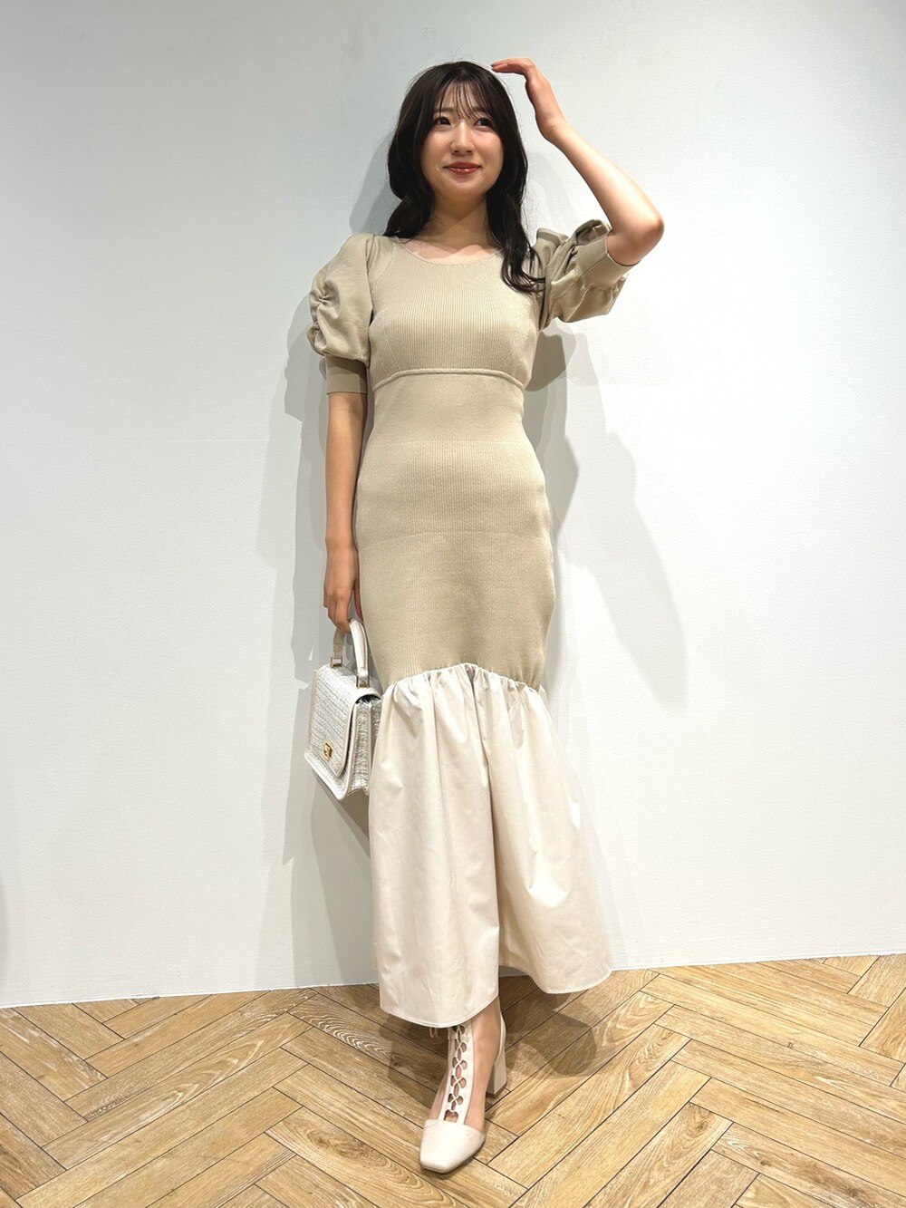 ブラウン系のテーラードジャケット、ベージュ系のワンピース、ホワイト系のブーツを着用したレディースの夏コーディネートの6枚目の写真