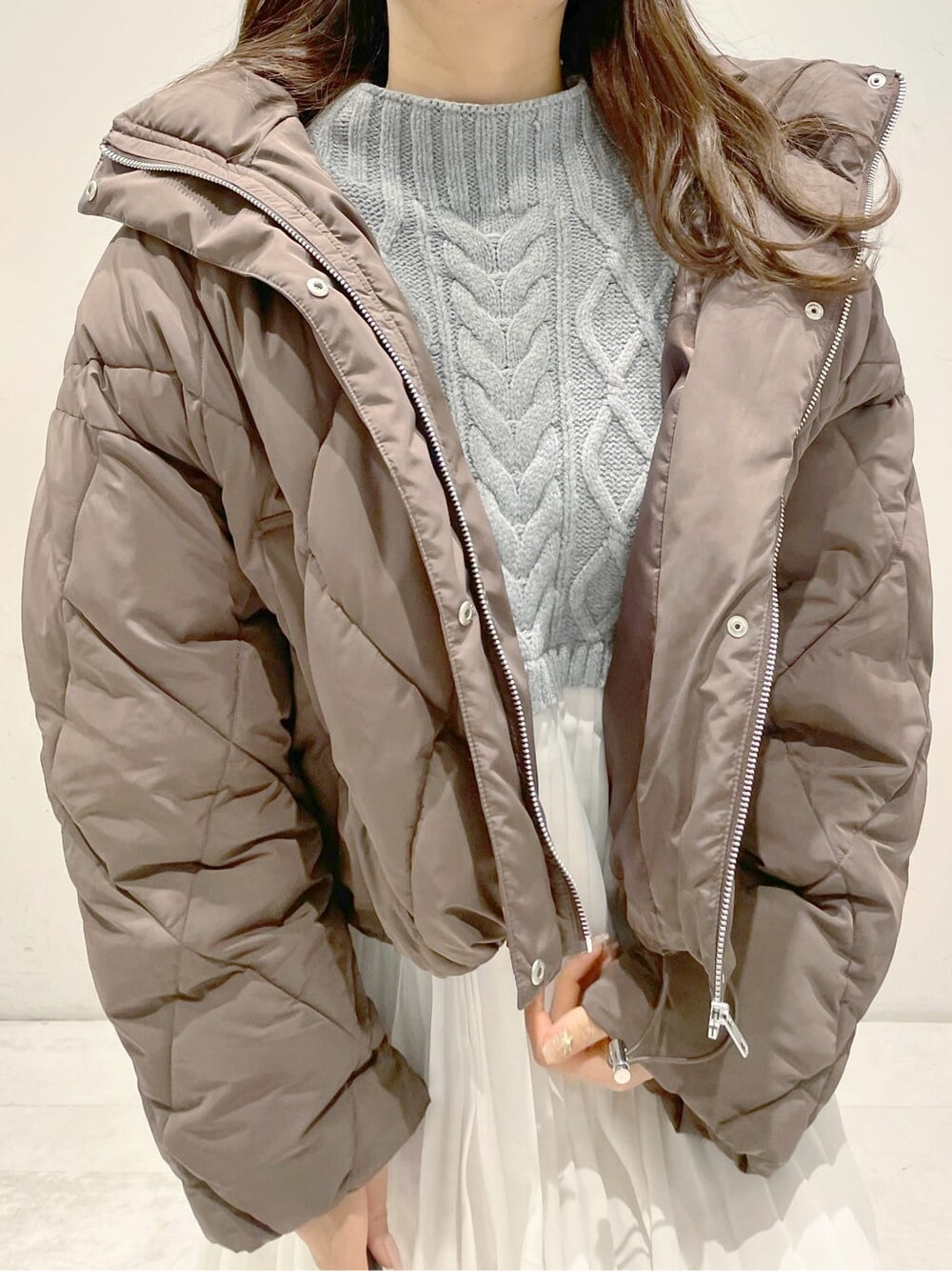 ブラウン系のブルゾン、ベージュ系のブーツ、グレー系のワンピースを着用したレディースの冬コーディネートの3枚目の写真