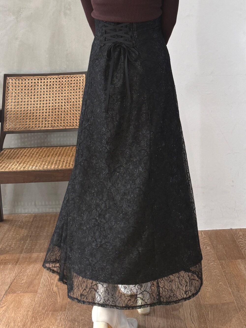 ブラウン系のニット/セーター、ブラック系のスカート、ホワイト系のブーツを着用したレディースの秋コーディネートの3枚目の写真