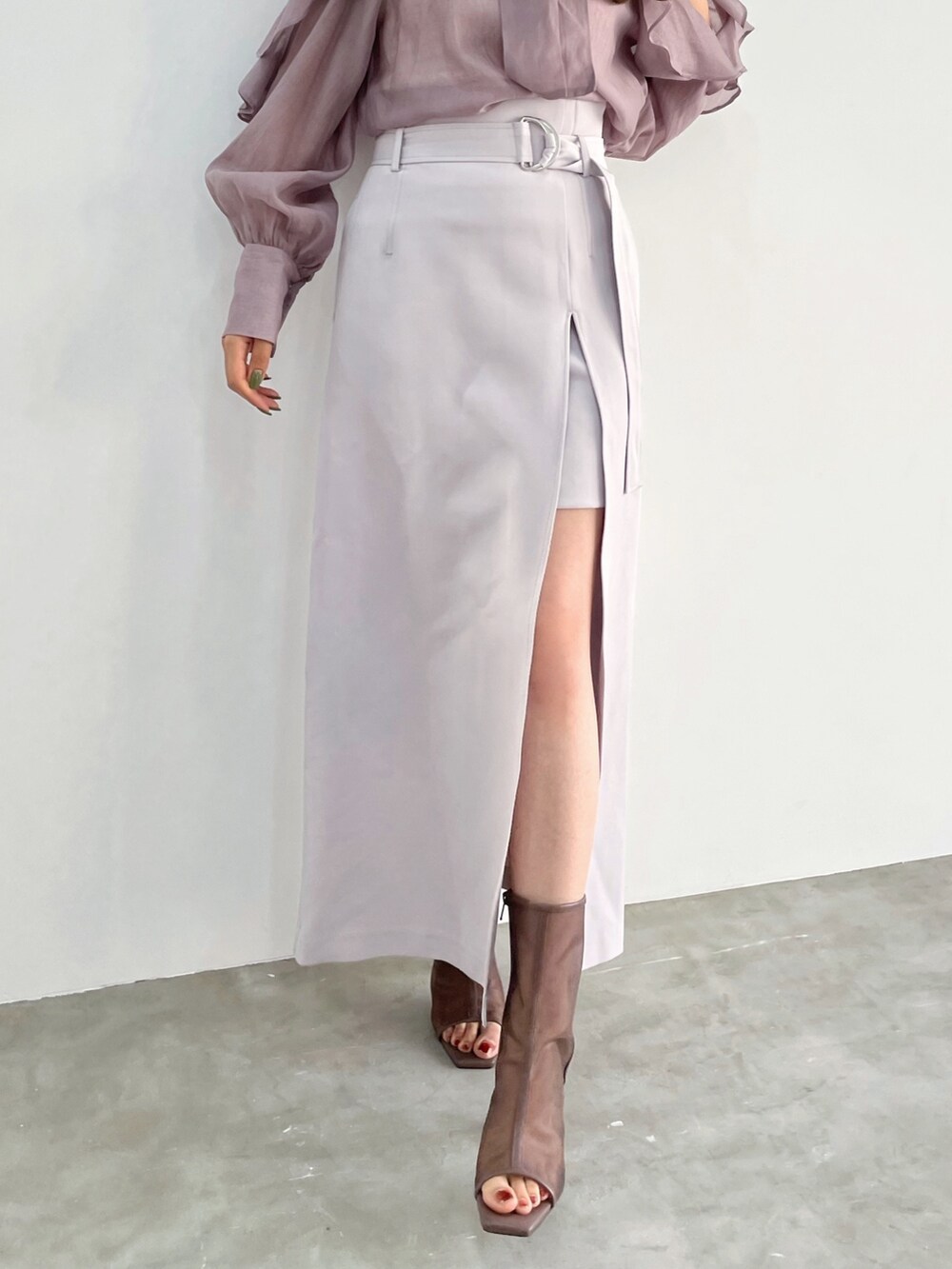 パープル系のシャツ/ブラウス、パープル系のスカート、ブラック系のブーツを着用したレディースの冬コーディネートの4枚目の写真