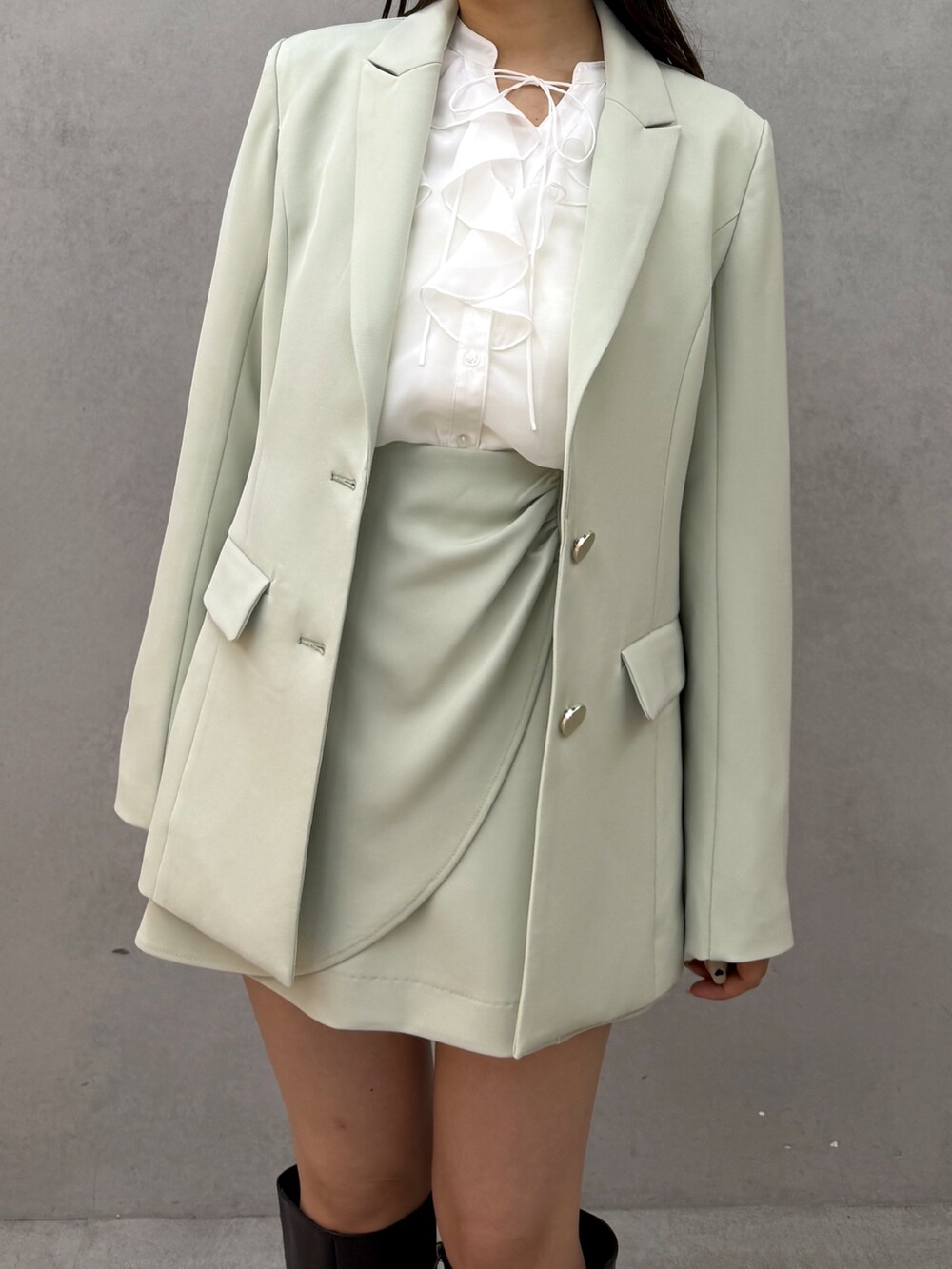 グリーン系のテーラードジャケット、ホワイト系のシャツ/ブラウス、グリーン系のスカートを着用したレディースの冬コーディネートの3枚目の写真