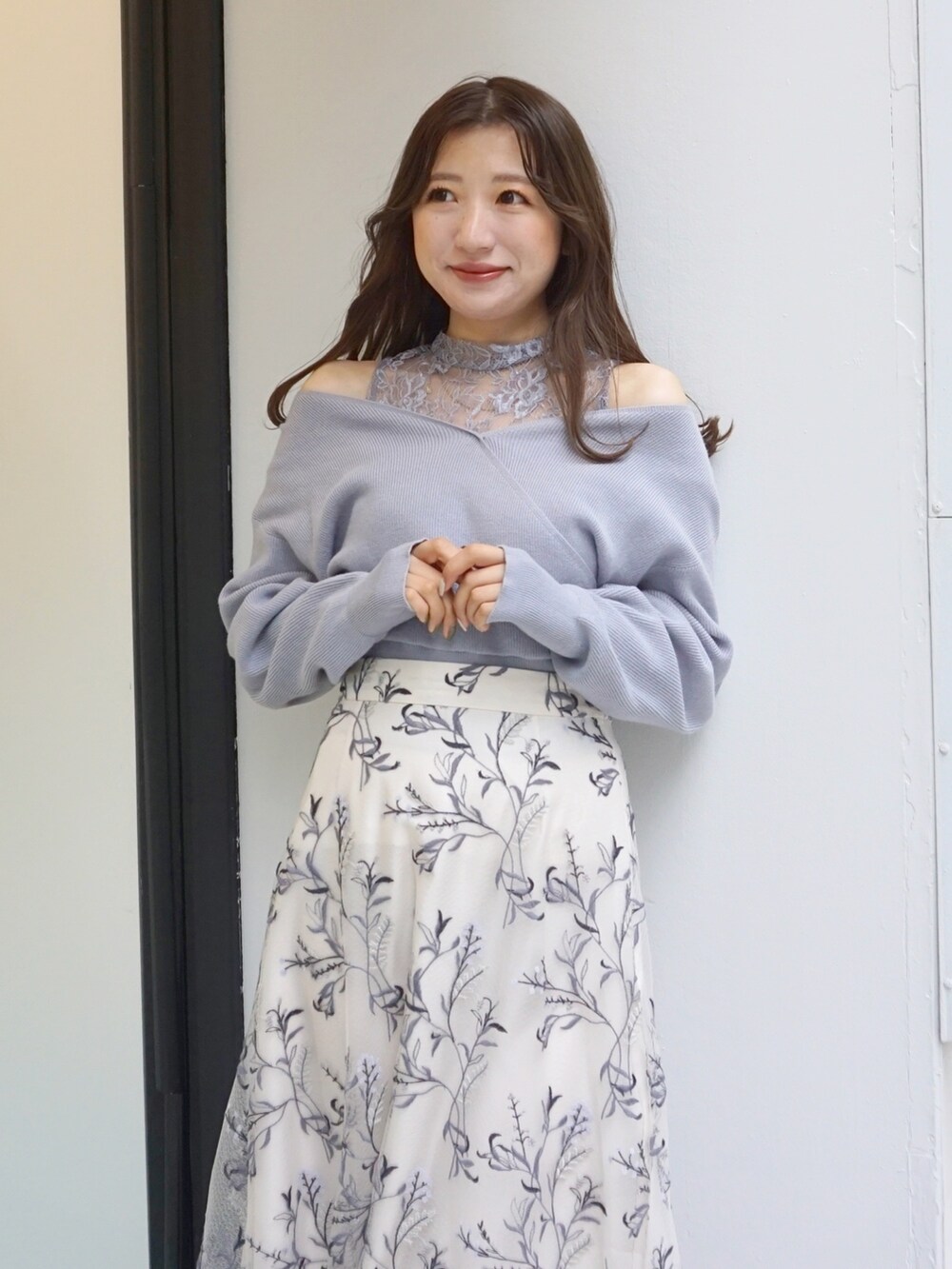 ブルー系のニット/セーター、ホワイト系のスカートを着用したレディースの秋コーディネートの4枚目の写真