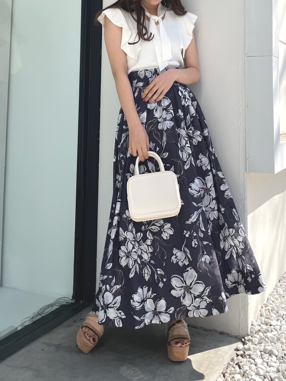 ホワイト系のニット/セーター、パープル系のスカート、ブラック系のハンドバッグを着用したレディースの春コーディネートの2枚目の写真