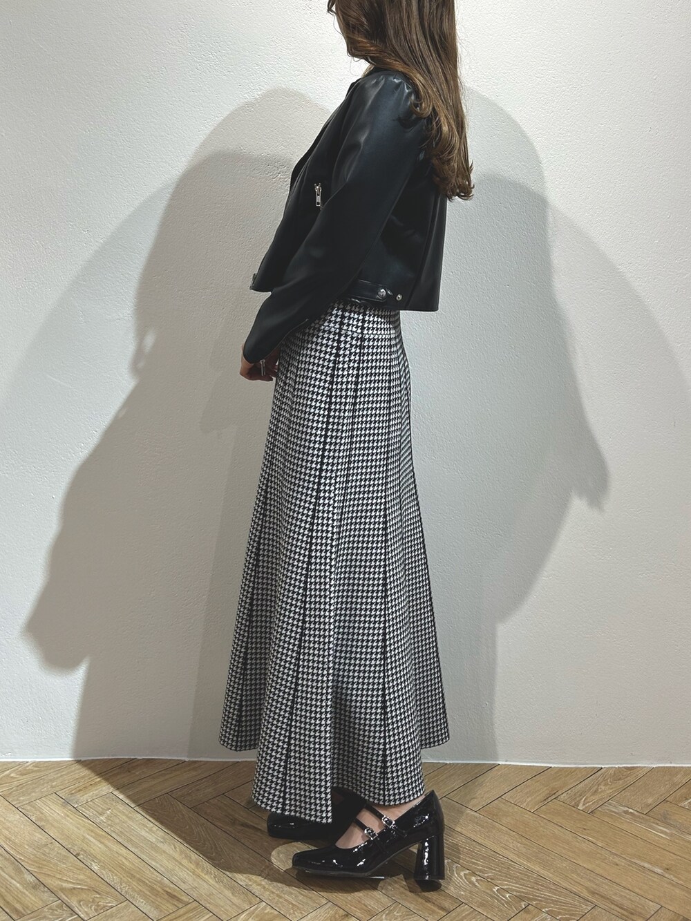 ブラック系のワンピース、ブラック系のライダースジャケット、レッド系のパンプスを着用したレディースの秋コーディネートの3枚目の写真