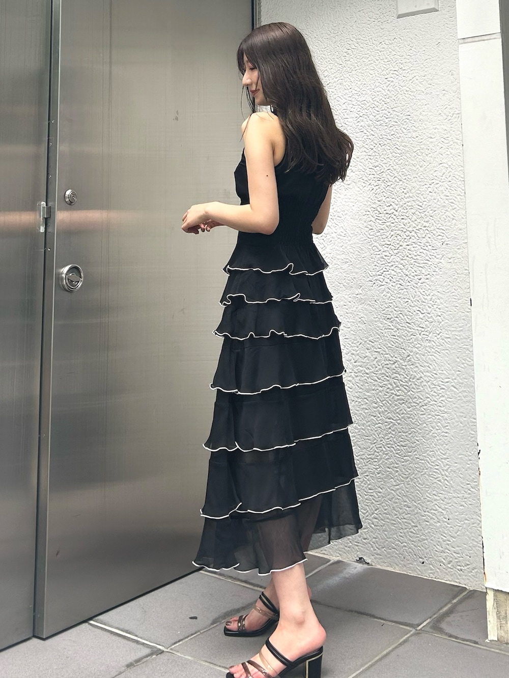 ブラック系のワンピースを着用したレディースの夏コーディネートの2枚目の写真