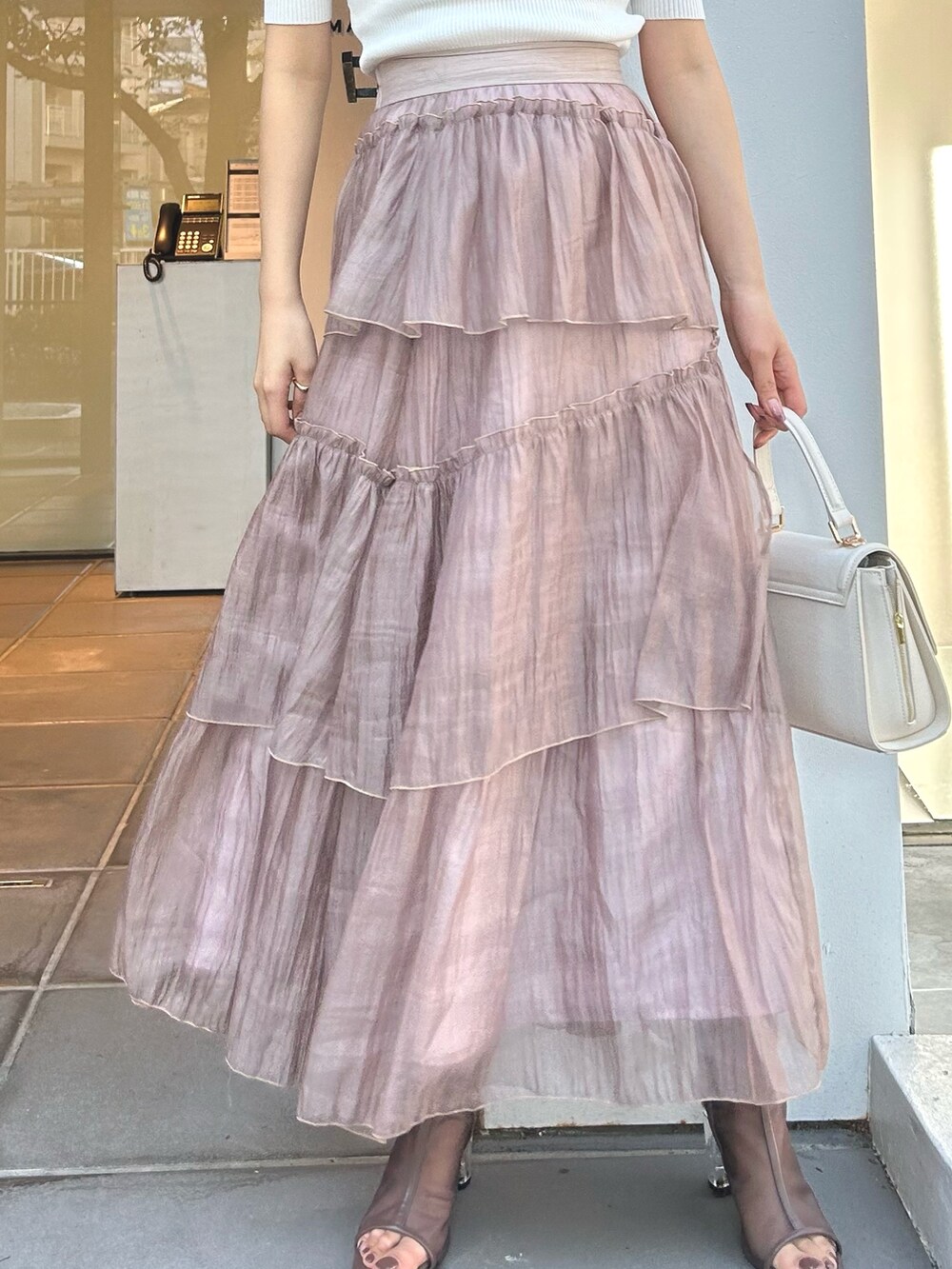 ホワイト系のニット/セーター、ブラウン系のスカート、ホワイト系のショルダーバッグを着用したレディースの冬コーディネートの5枚目の写真