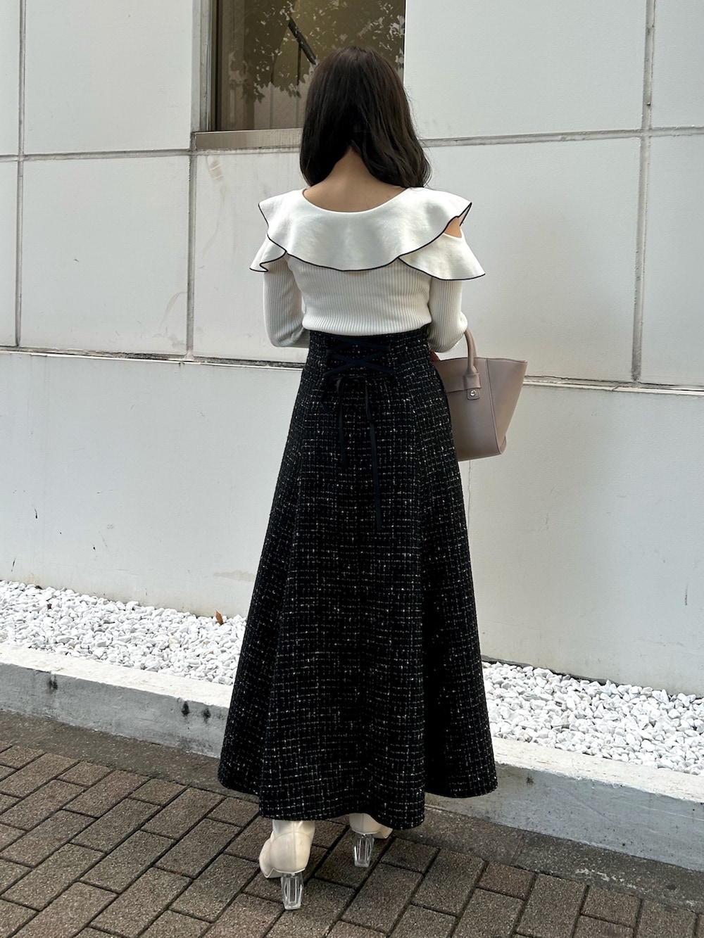 その他のニット/セーター、ベージュ系のハンドバッグ、ブラック系のスカートを着用したレディースの秋コーディネートの4枚目の写真