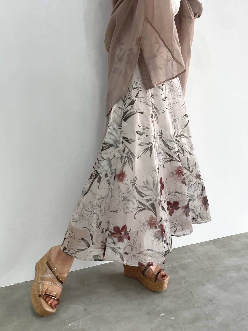 ピンク系のスカート、ホワイト系のニット/セーター、ベージュ系のシャツ/ブラウスを着用したレディースの春コーディネートの6枚目の写真