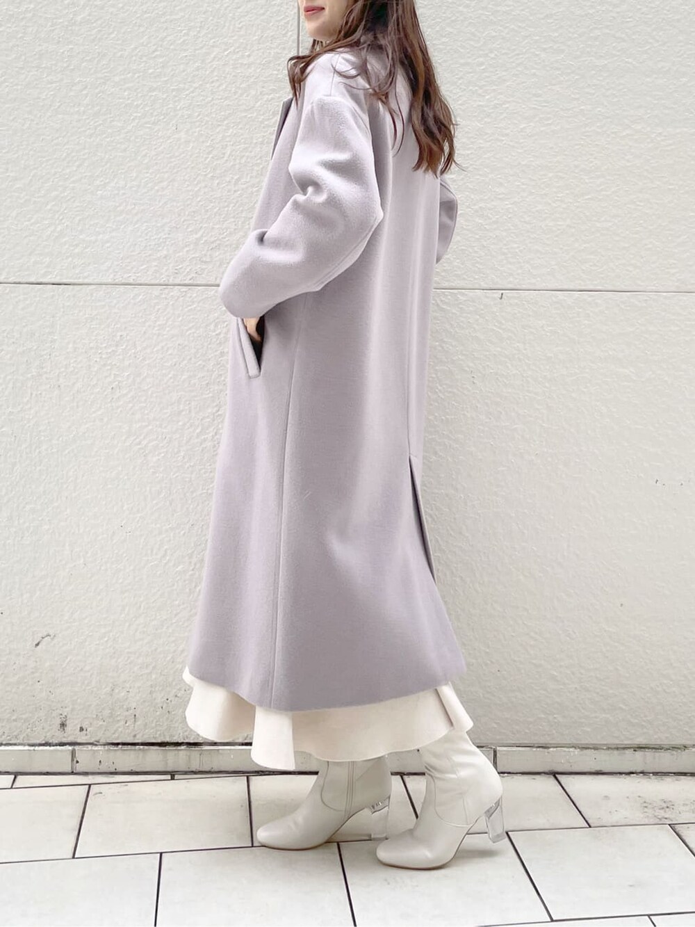 ピンク系のチェスターコート、ホワイト系のその他シューズを着用したレディースの冬コーディネートの2枚目の写真