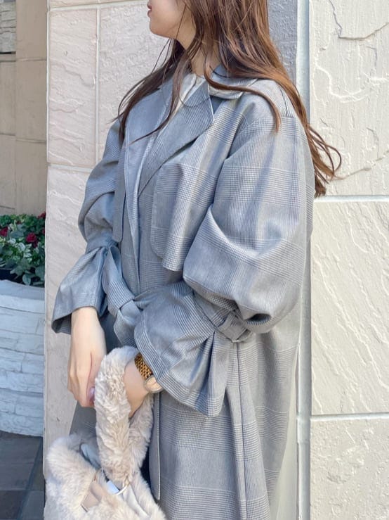 ブラウン系のその他シューズ、その他のチェスターコート、ベージュ系のハンドバッグを着用したレディースの秋コーディネートの5枚目の写真