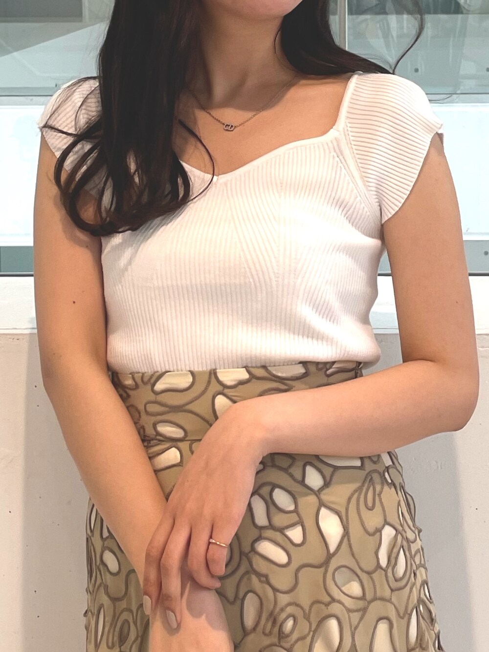 ホワイト系のニット/セーター、ブラウン系のサンダル、イエロー系のスカートを着用したレディースの春コーディネートの4枚目の写真