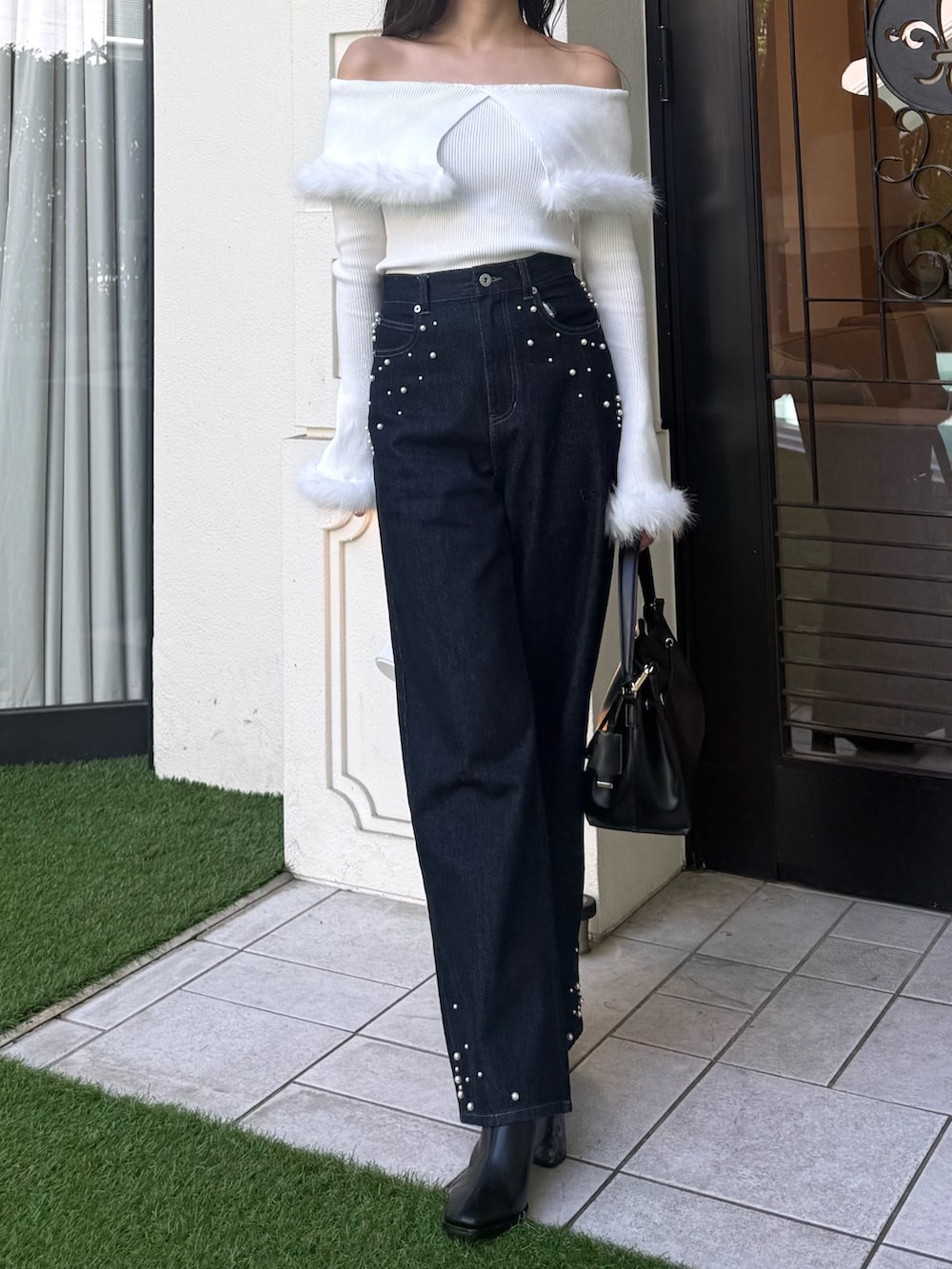 ホワイト系のニット/セーター、ブルー系のダウンジャケット/コート、ブルー系のデニムパンツを着用したレディースの秋コーディネートの3枚目の写真