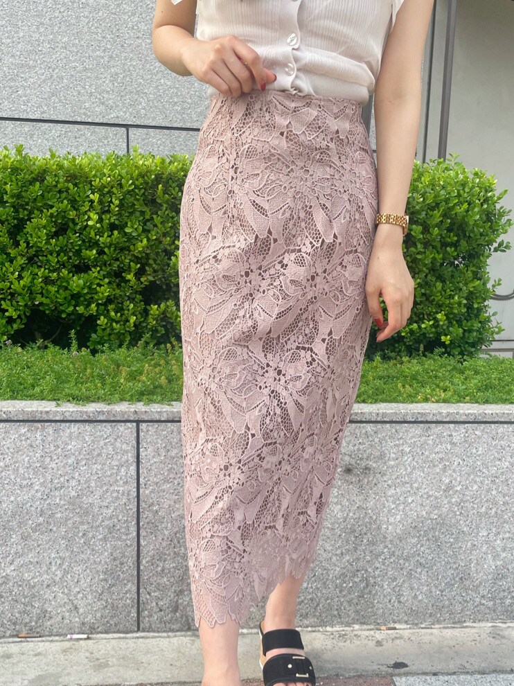 ベージュ系のスカート、ホワイト系のニット/セーターを着用したレディースの春コーディネートの6枚目の写真