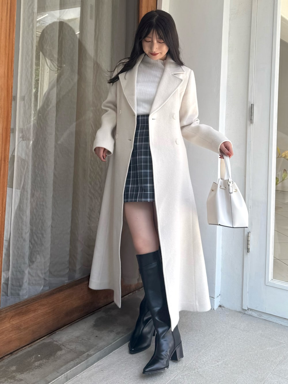 グリーン系のスカート、ホワイト系のニット/セーター、ホワイト系のショルダーバッグを着用したレディースの秋コーディネートの5枚目の写真