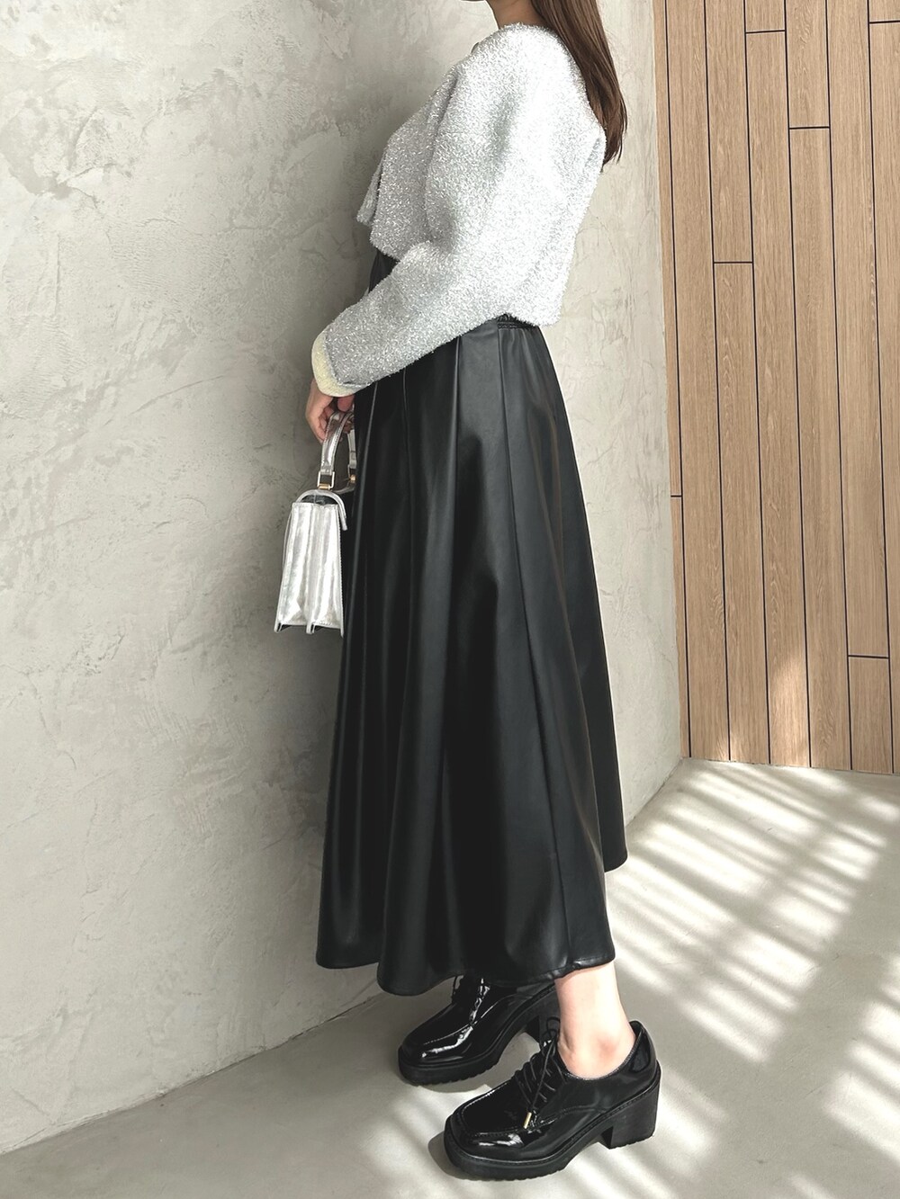 シルバー系のカーディガン/ボレロ、ブラック系のスカート、ブラック系のローファーを着用したレディースの冬コーディネートの2枚目の写真