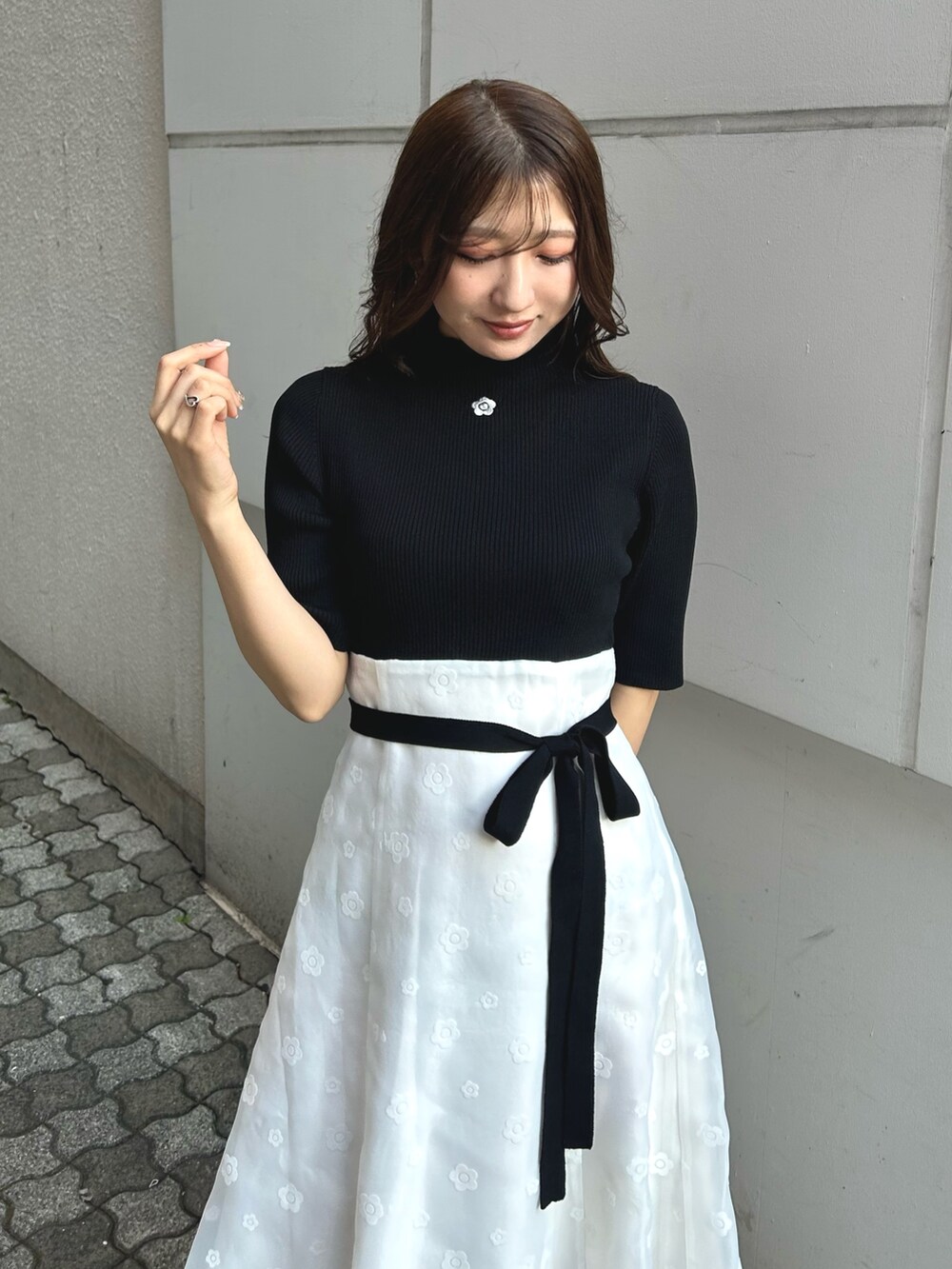 ブラック系のワンピース、ホワイト系のパンプス、パープル系のトレンチコートを着用したレディースの冬コーディネートの4枚目の写真