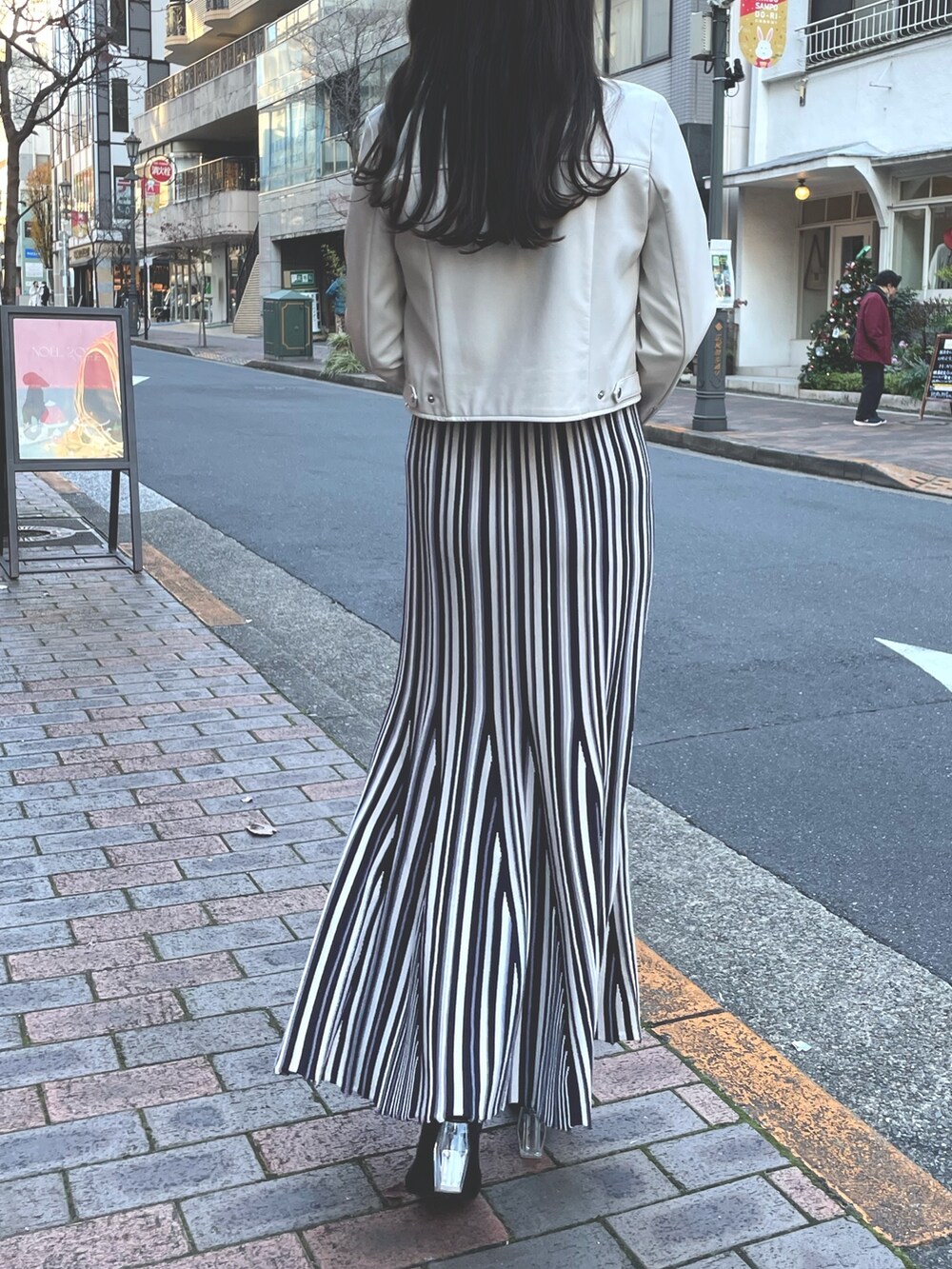 パープル系のワンピース、ホワイト系のライダースジャケットを着用したレディースの冬コーディネートの7枚目の写真