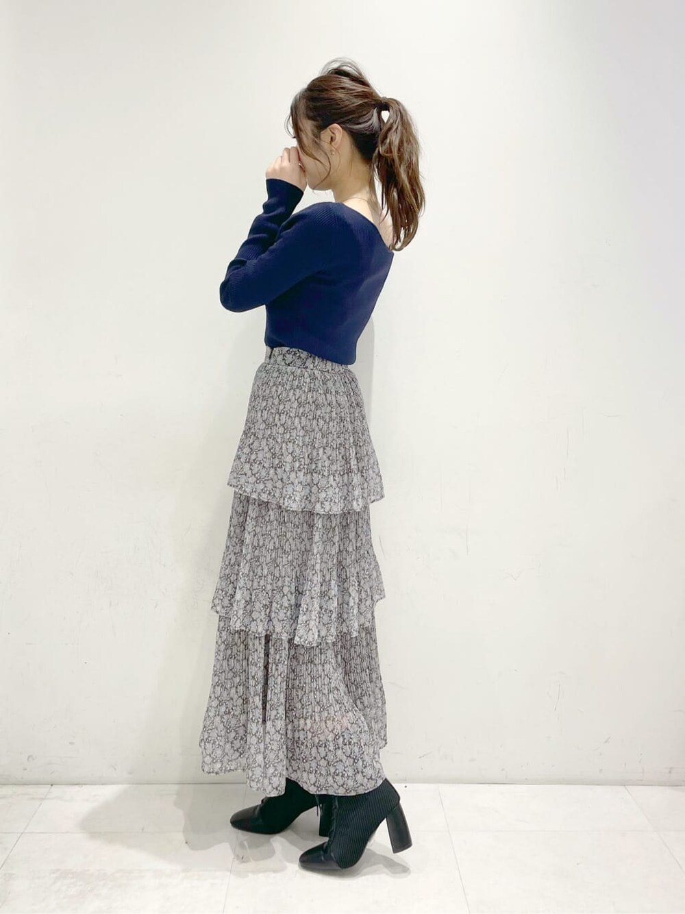 ブラック系のブーツ、ブルー系のスカート、ブルー系のニット/セーターを着用したレディースの冬コーディネートの2枚目の写真