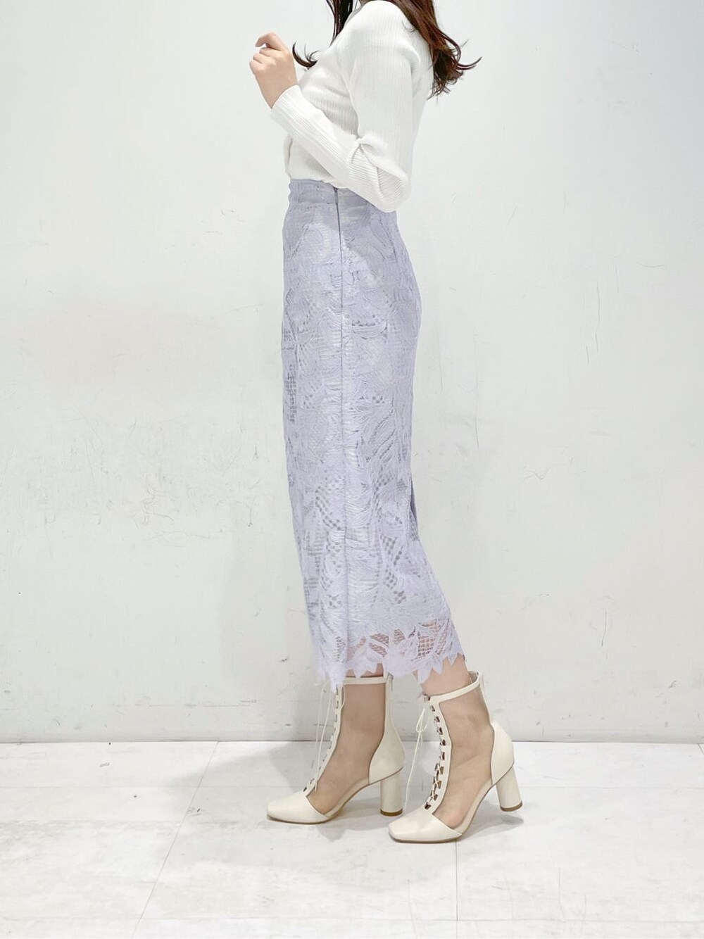 パープル系のスカート、ホワイト系のその他シューズ、ホワイト系のカーディガン/ボレロを着用したレディースの冬コーディネートの2枚目の写真