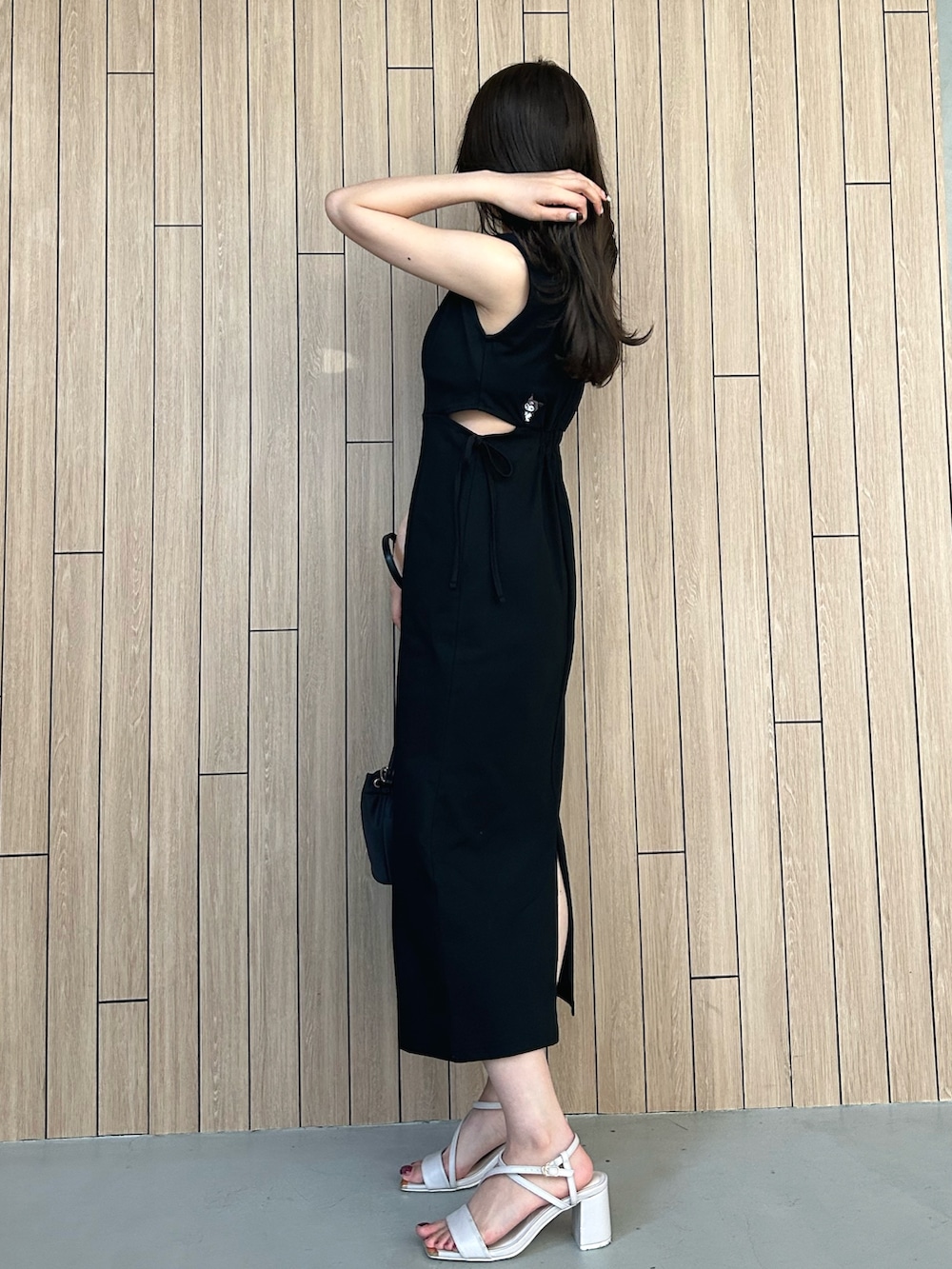 ブラック系のショルダーバッグ、ベージュ系のサンダル、ブラック系のワンピースを着用したレディースの春コーディネートの3枚目の写真