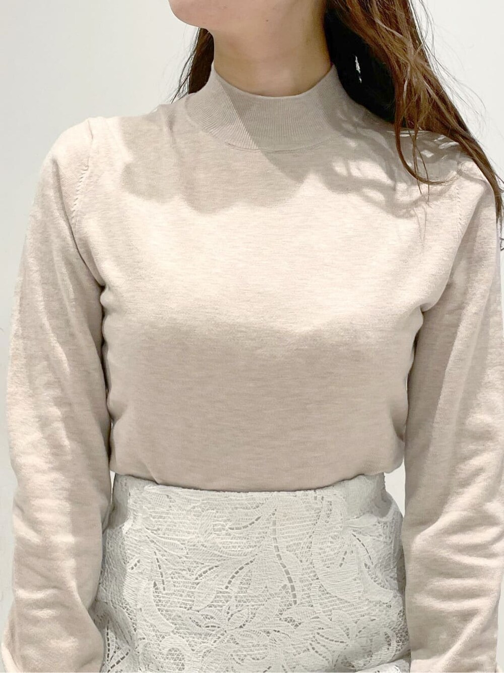 ベージュ系のパンプス、ベージュ系のニット/セーター、ホワイト系のスカートを着用したレディースの冬コーディネートの3枚目の写真