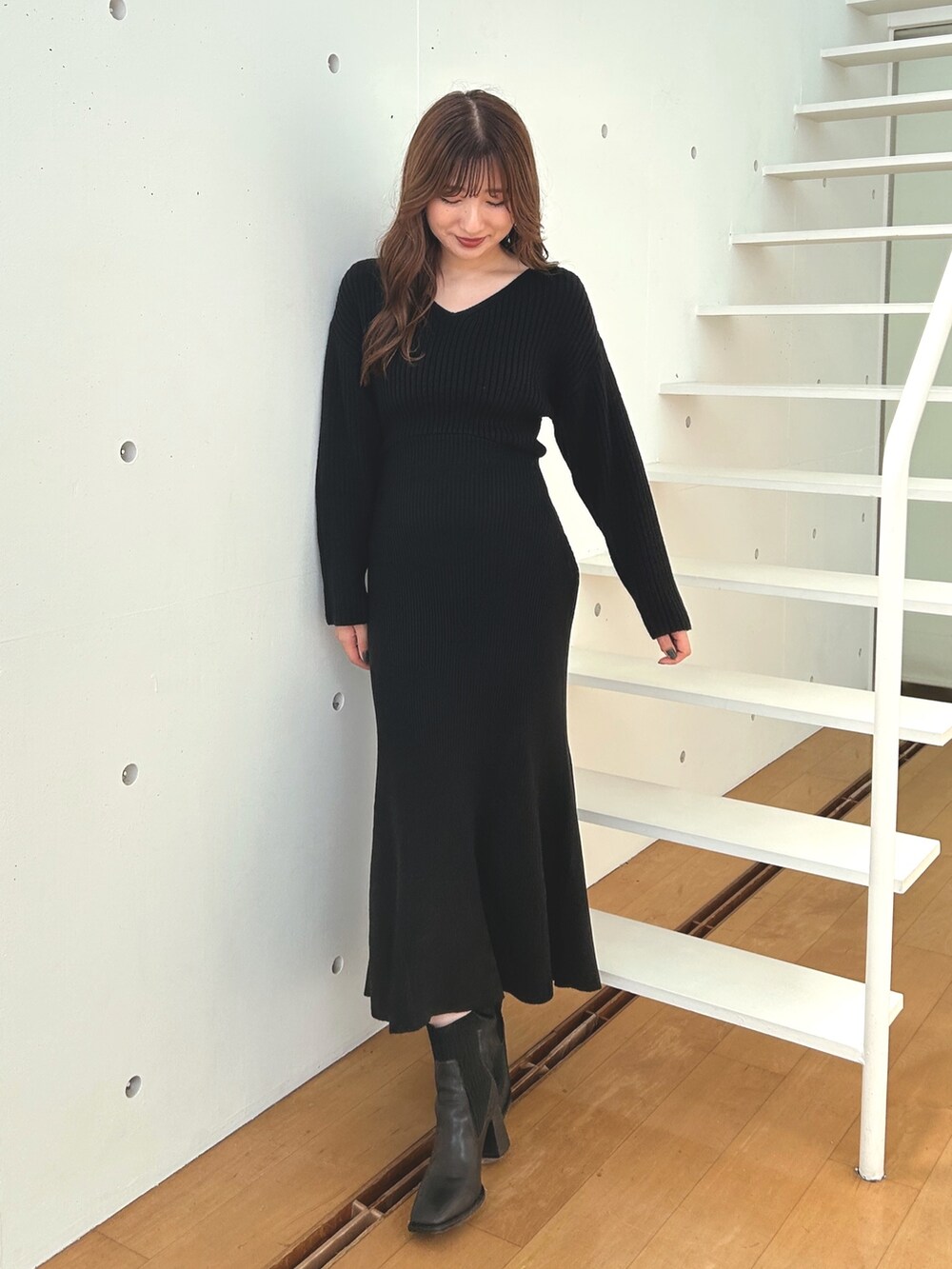 ブラック系のワンピース、ブラック系のブーツを着用したレディースの秋コーディネートの3枚目の写真