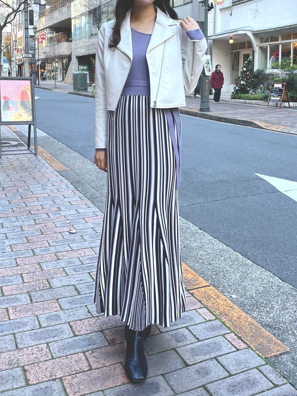 パープル系のワンピース、ホワイト系のライダースジャケットを着用したレディースの冬コーディネートの5枚目の写真