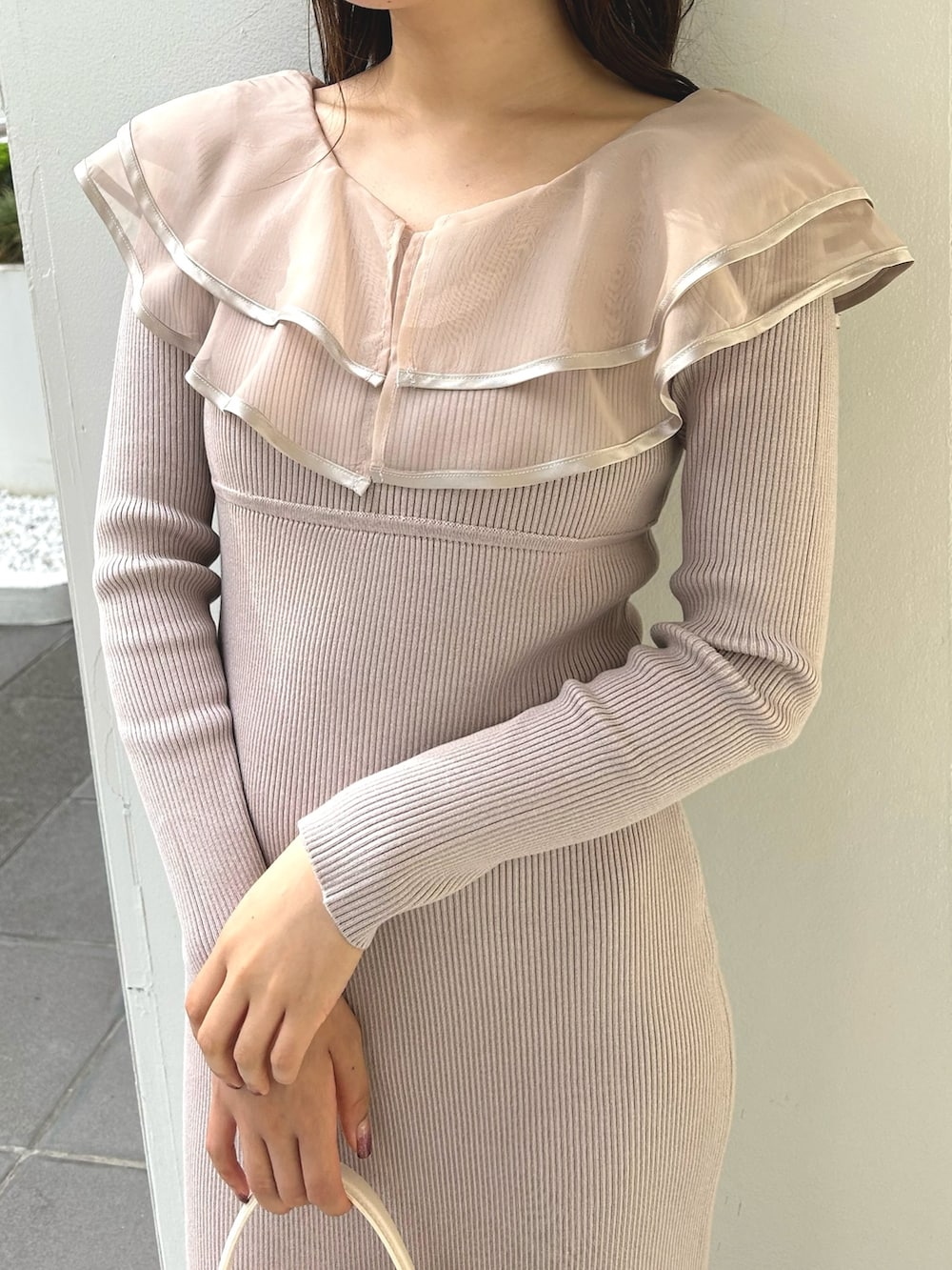 ピンク系のワンピース、ホワイト系のショルダーバッグ、ホワイト系のダウンジャケット/コートを着用したレディースの冬コーディネートの5枚目の写真