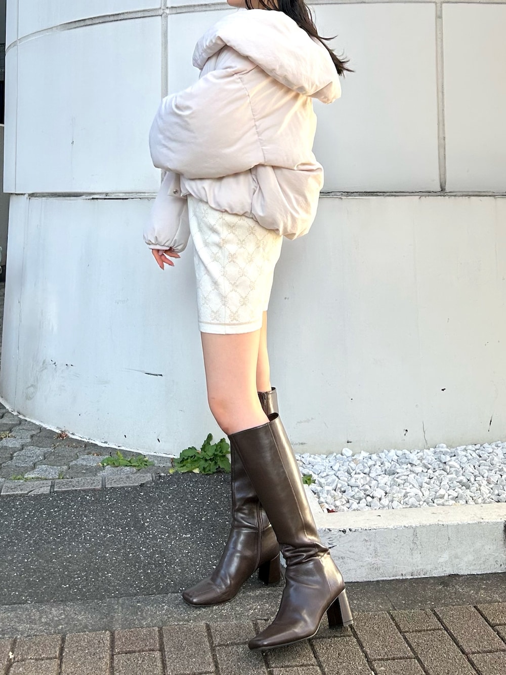 ホワイト系のワンピース、ホワイト系のダウンジャケット/コート、ブラウン系のブーツを着用したレディースの冬コーディネートの3枚目の写真