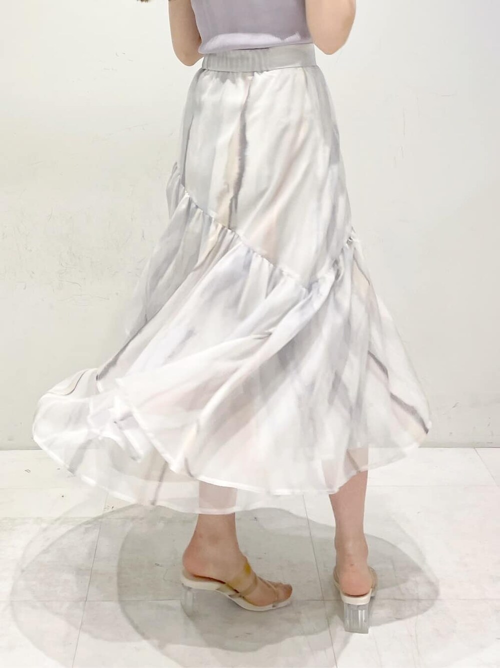 ピンク系のスカート、ベージュ系のサンダル、パープル系のニット/セーターを着用したレディースの春コーディネートの10枚目の写真