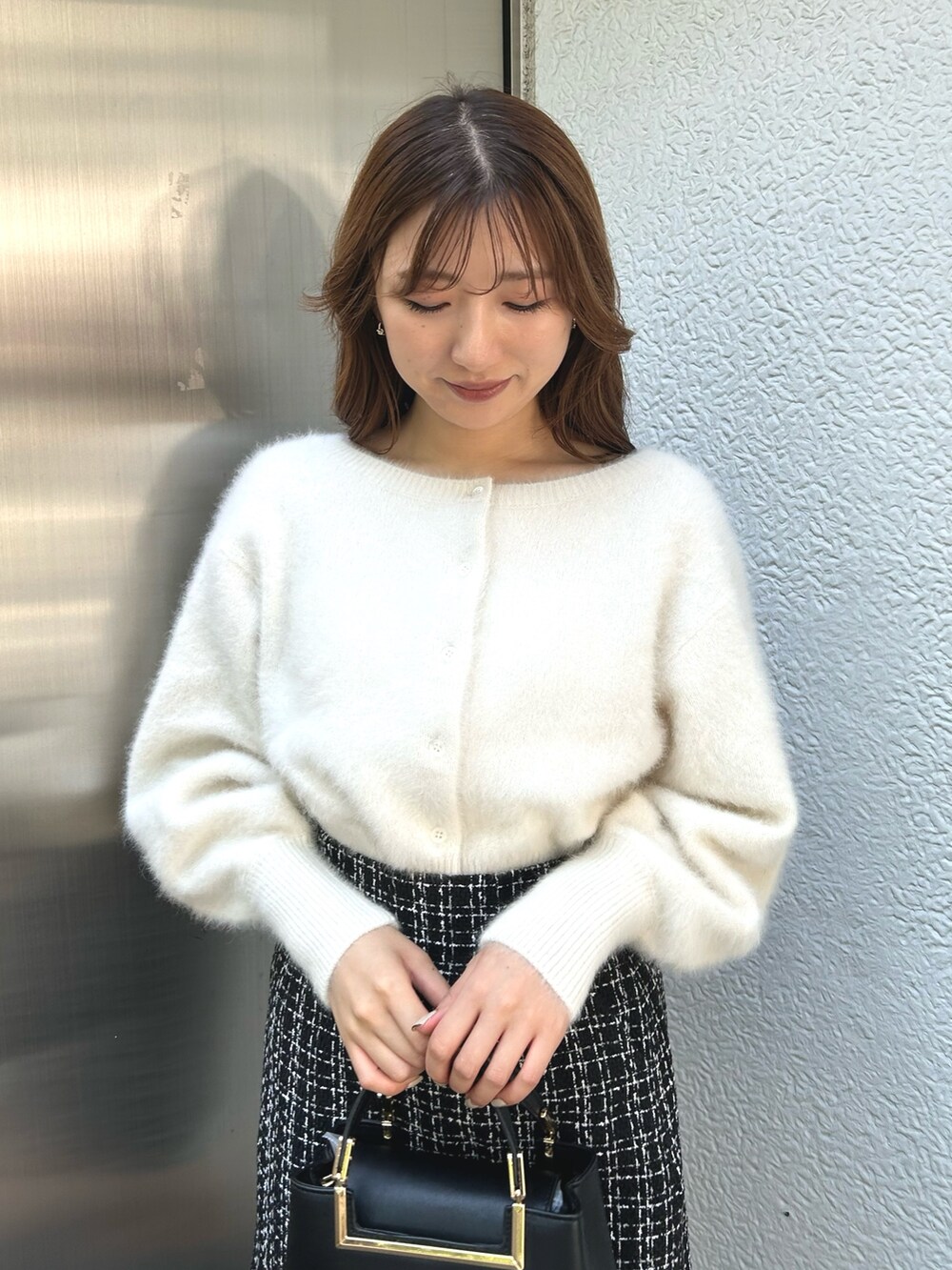 ホワイト系のカーディガン/ボレロ、ブラック系のスカート、ブラック系のブーツを着用したレディースの秋コーディネートの6枚目の写真