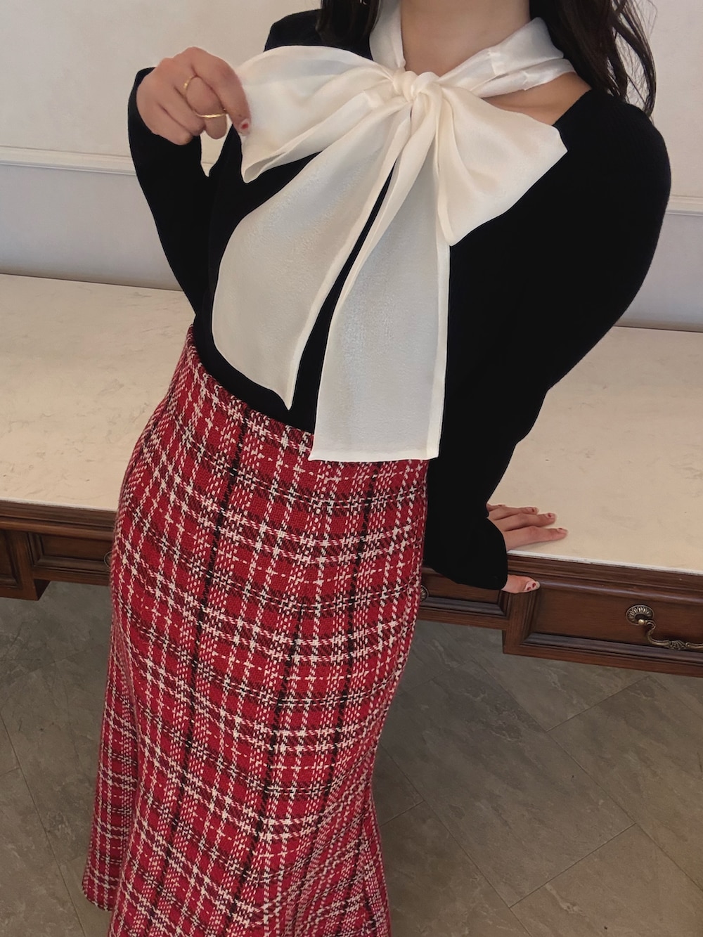 ブラック系のニット/セーター、レッド系のスカートを着用したレディースの秋コーディネートの4枚目の写真