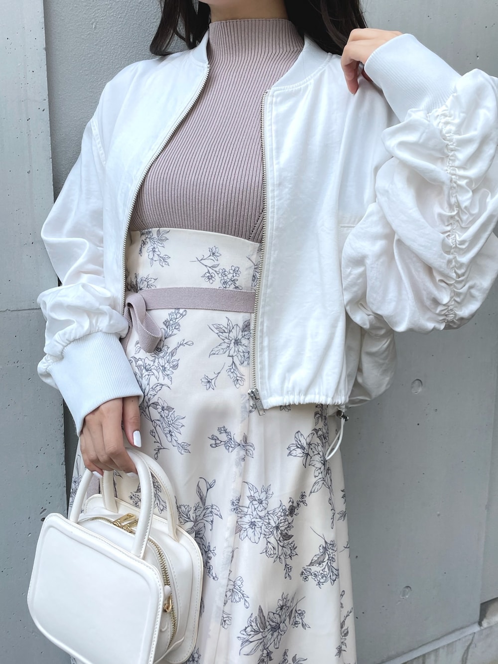 ブラック系のブーツ、ブラック系のハンドバッグ、ホワイト系のワンピースを着用したレディースの春コーディネートの7枚目の写真