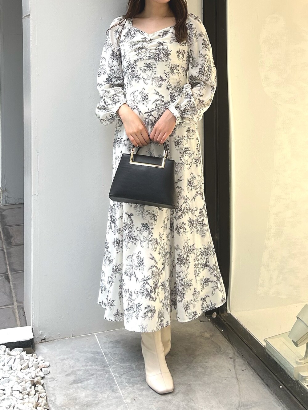 ブラック系のハンドバッグ、ホワイト系のワンピースを着用したレディースの夏コーディネートの2枚目の写真