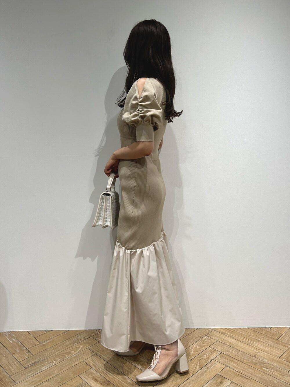 ブラウン系のテーラードジャケット、ベージュ系のワンピース、ホワイト系のブーツを着用したレディースの夏コーディネートの7枚目の写真