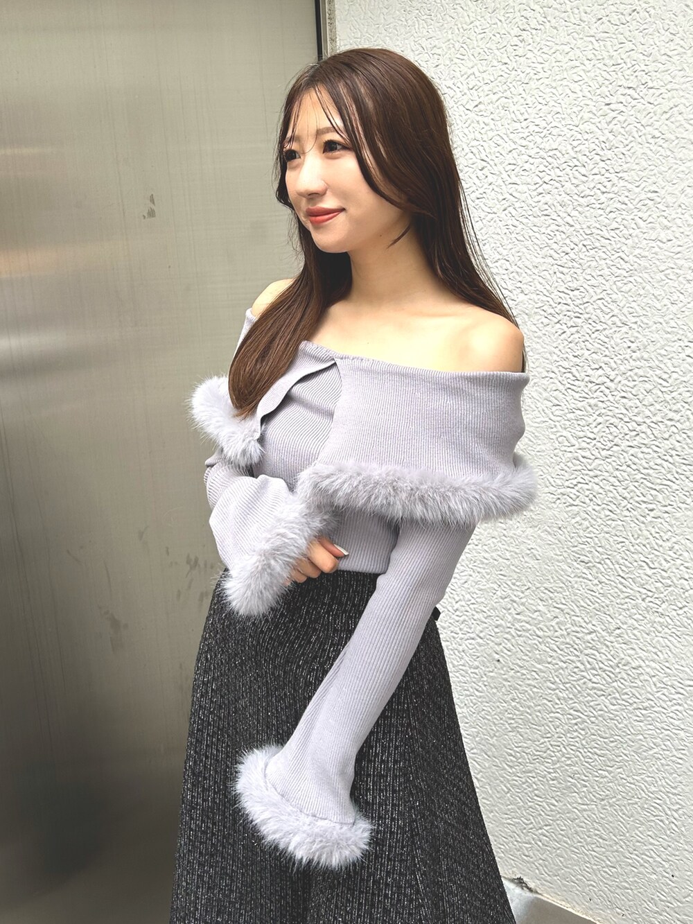 グレー系のニット/セーター、ブラック系のスカート、ブラウン系のブーツを着用したレディースの冬コーディネートの4枚目の写真