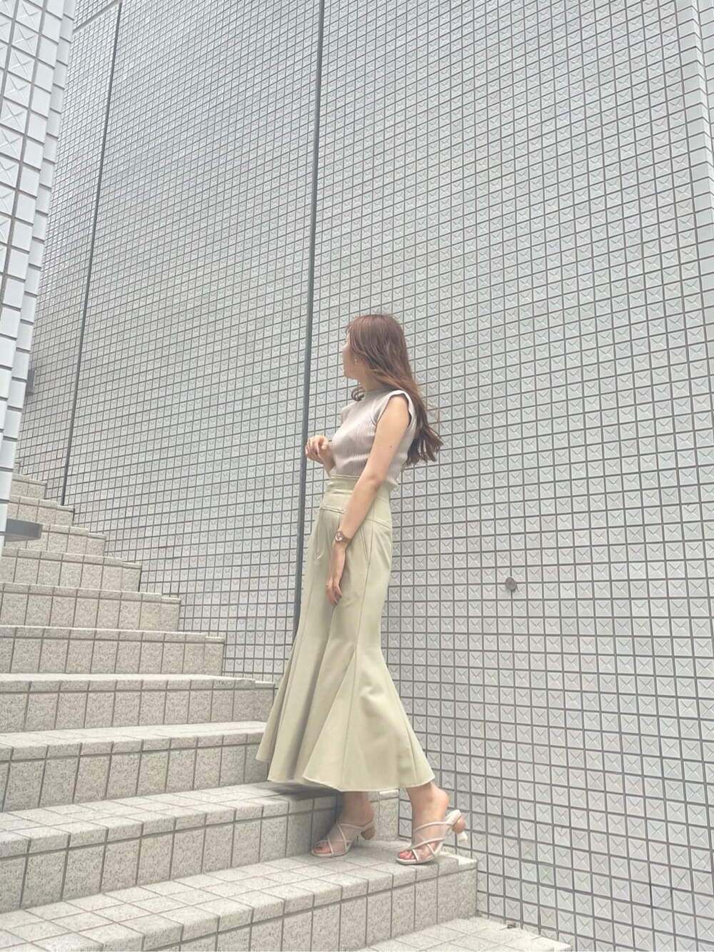 ベージュ系のニット/セーター、ベージュ系のサンダルを着用したレディースの夏コーディネートの3枚目の写真