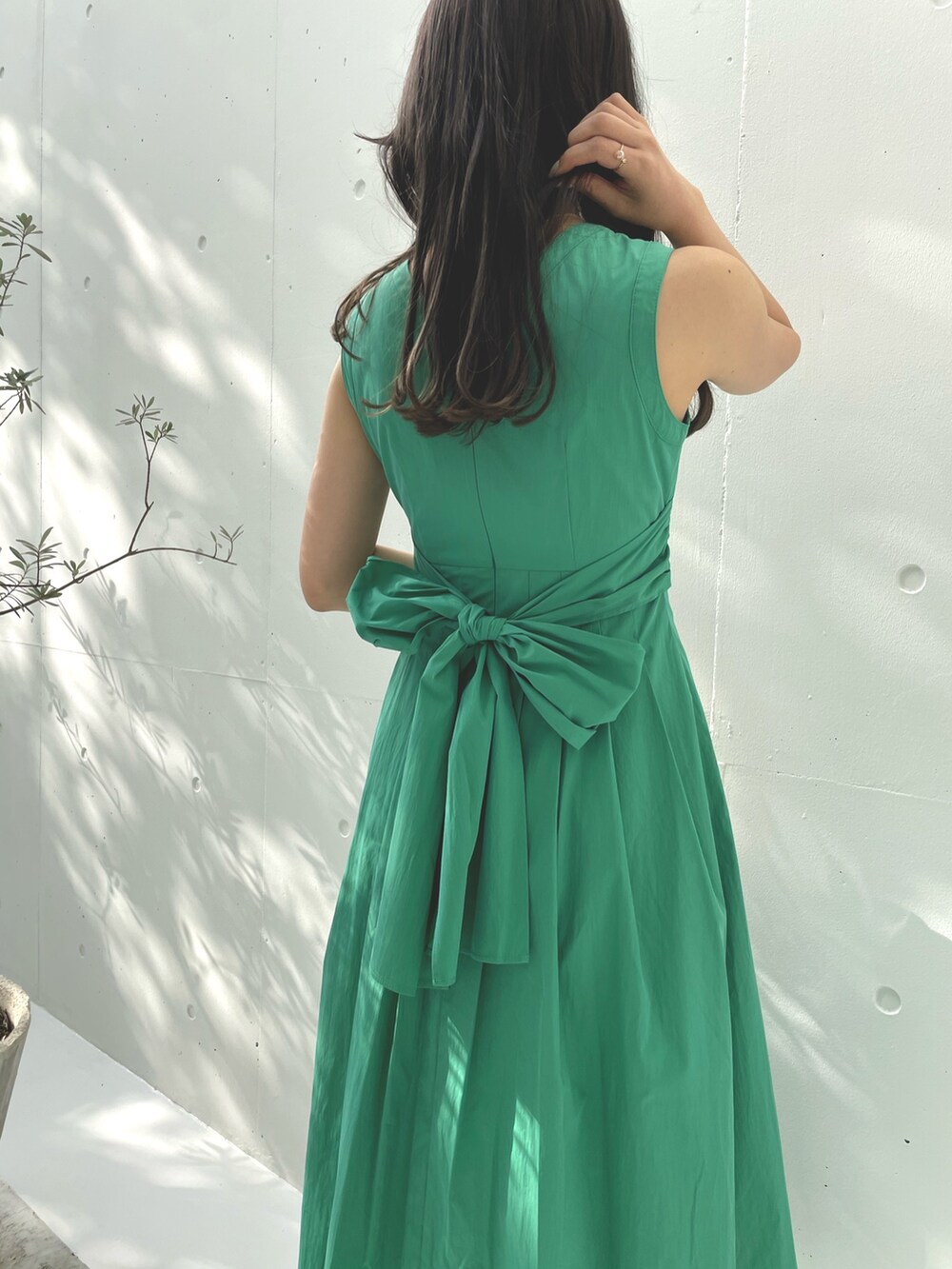 グリーン系のワンピース、ホワイト系のハンドバッグ、ホワイト系のサンダルを着用したレディースの夏コーディネートの4枚目の写真