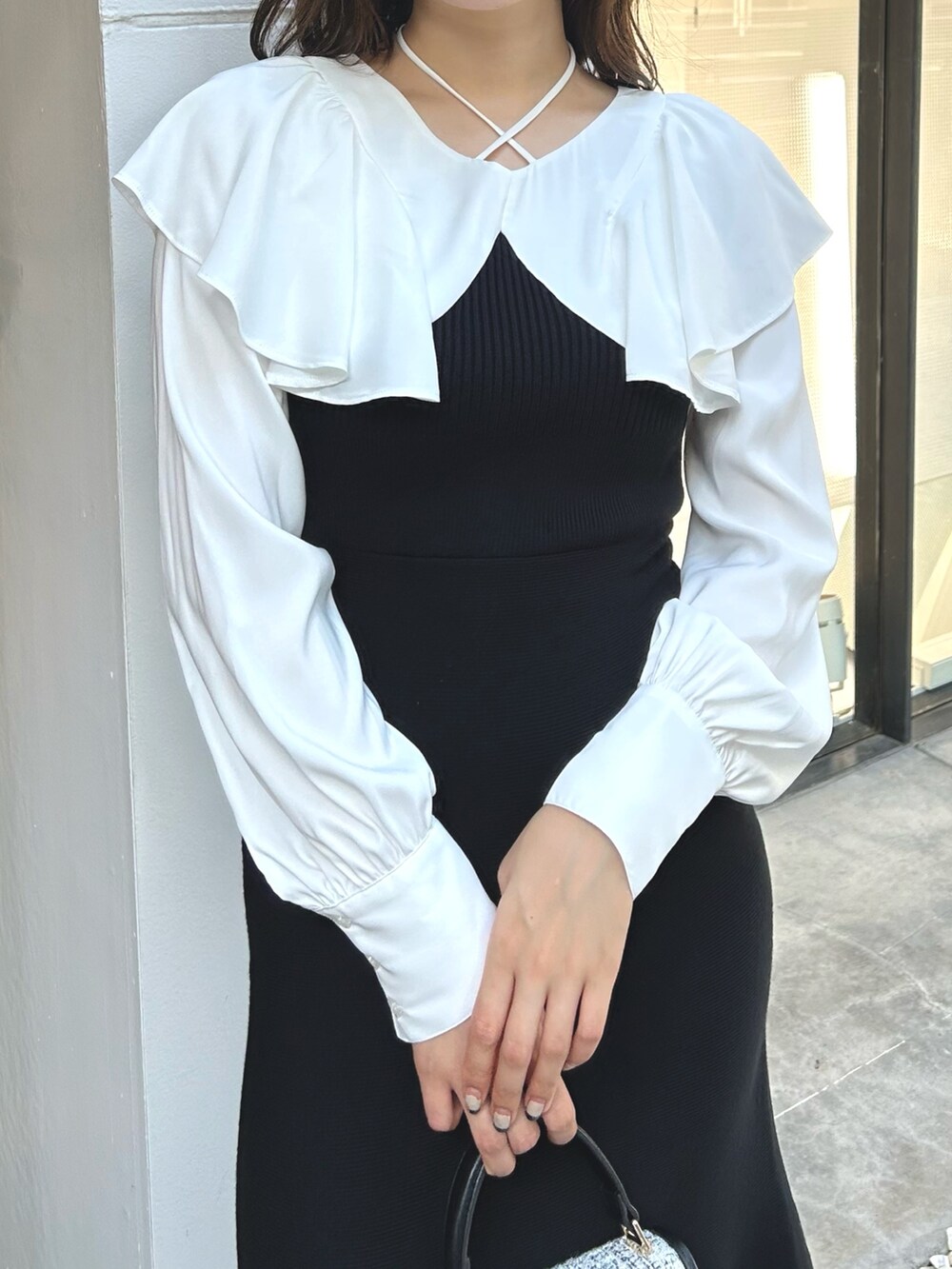 ブラック系のワンピース、ブラック系のショルダーバッグ、ブラック系のブーツを着用したレディースの秋コーディネートの5枚目の写真