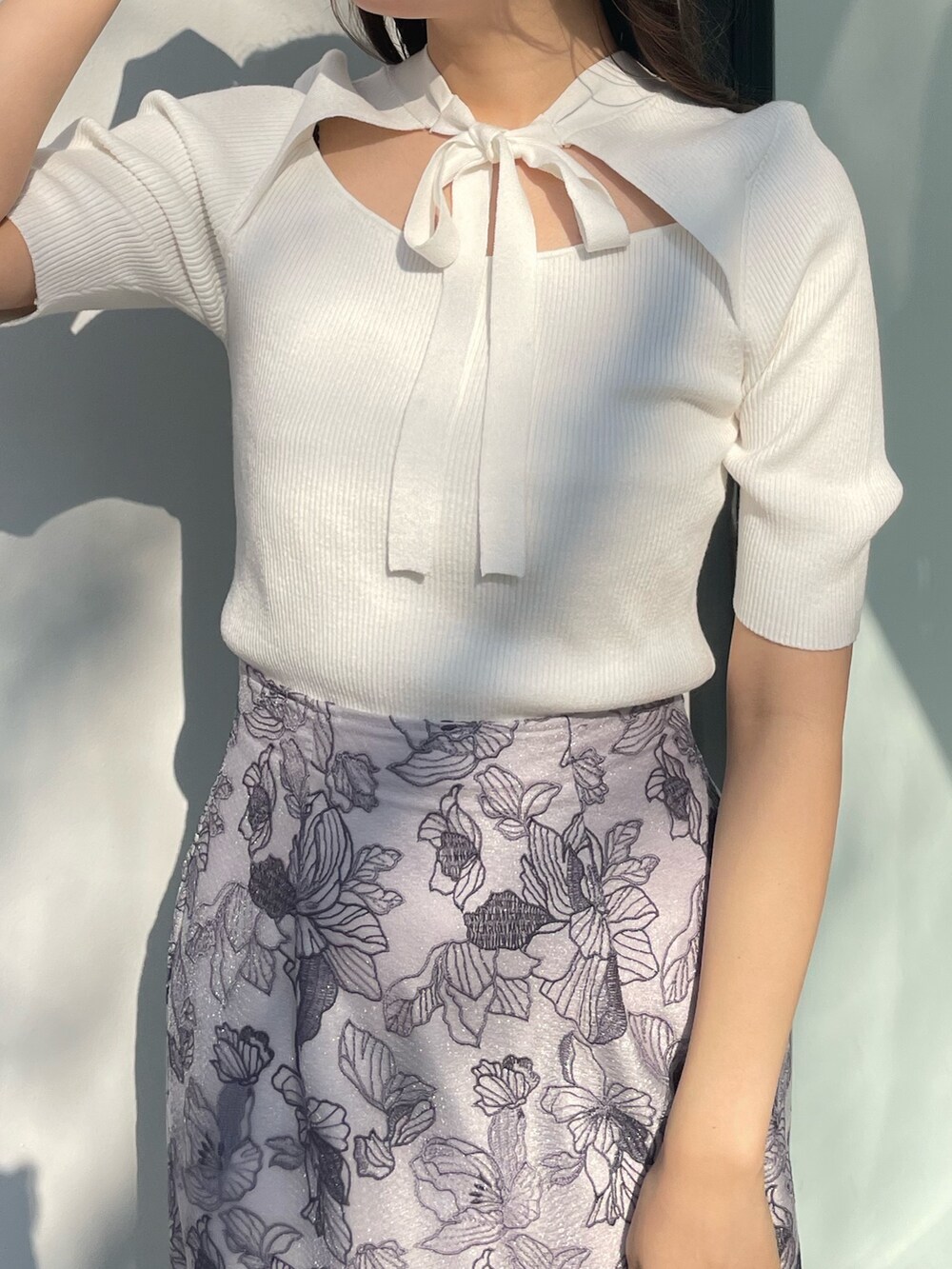 ホワイト系のスカート、ホワイト系のニット/セーター、ブラック系のブーツを着用したレディースの春コーディネートの4枚目の写真