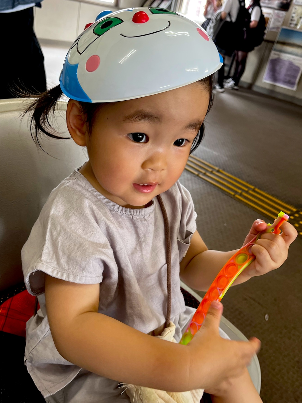 グレー系のセットアップ、ベージュ系のバッグ、ベージュ系の帽子を着用したキッズの夏コーディネートの5枚目の写真