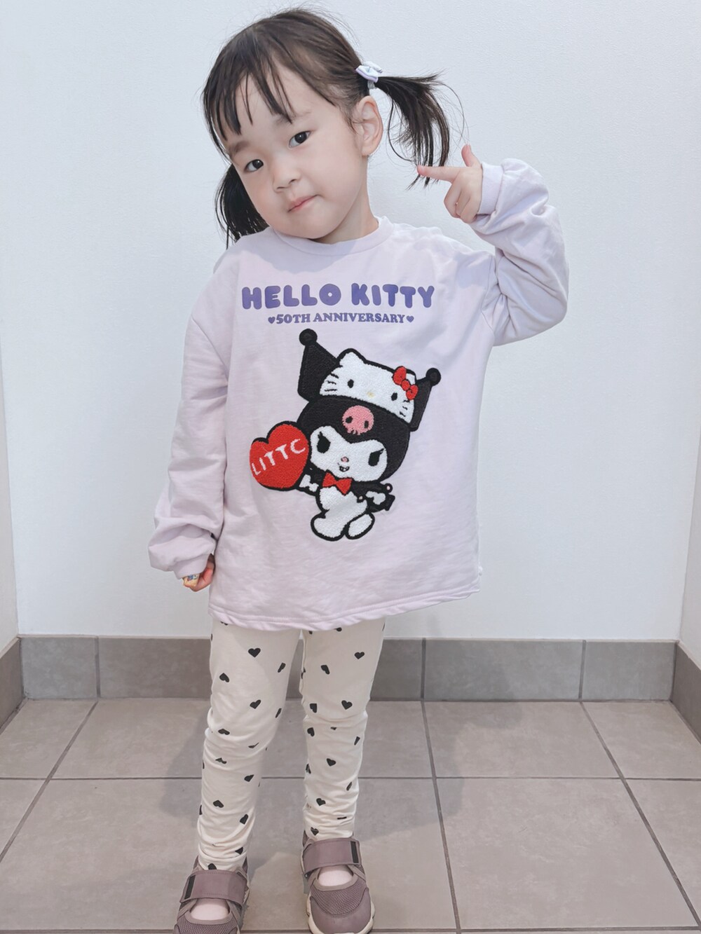 パープル系のトップス、ベージュ系のパンツ、パープル系のシューズを着用したキッズの秋コーディネートの3枚目の写真