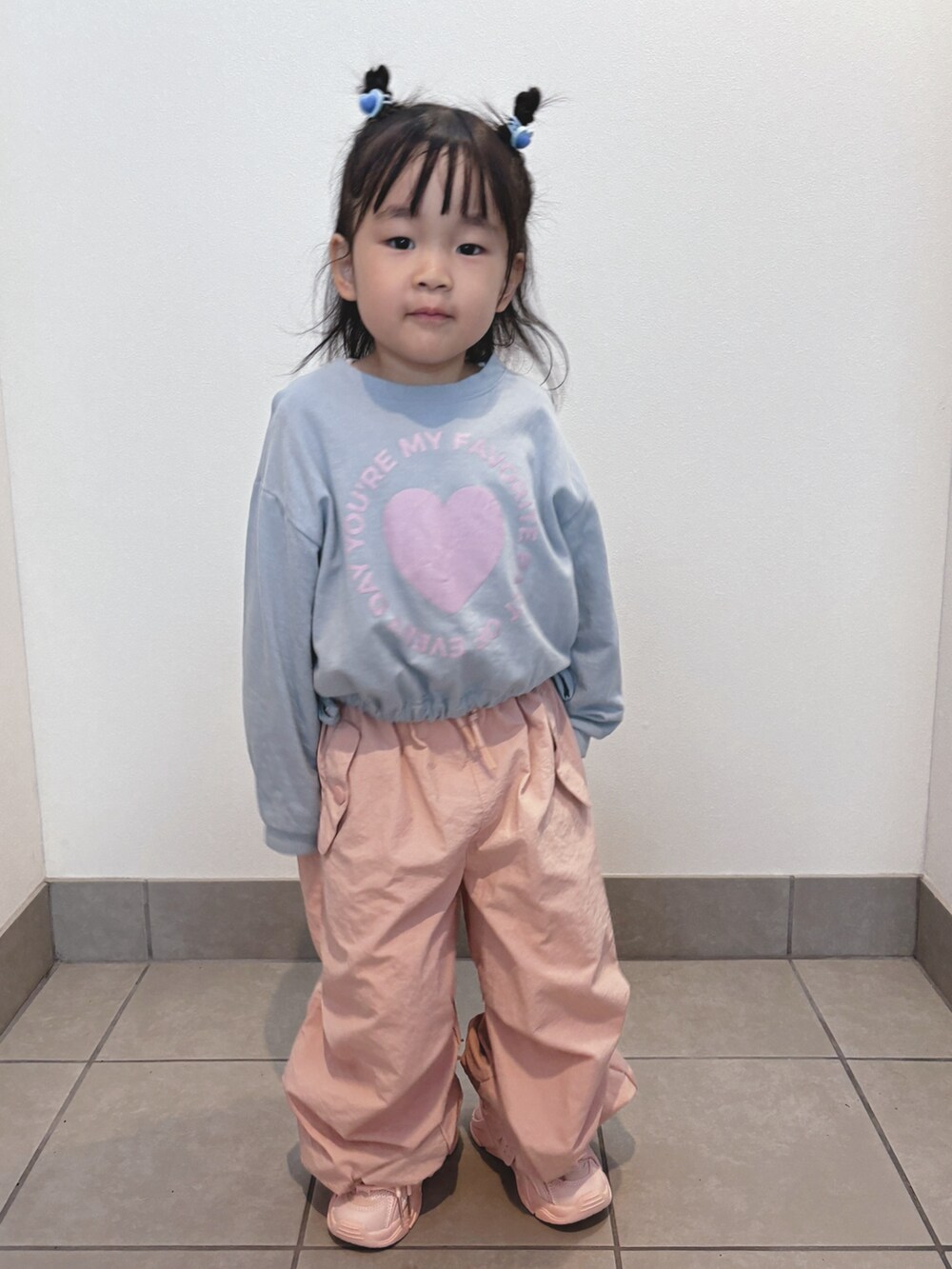 ブルー系のトップス、ピンク系のパンツ、ピンク系のスニーカーを着用したキッズの秋コーディネートの5枚目の写真