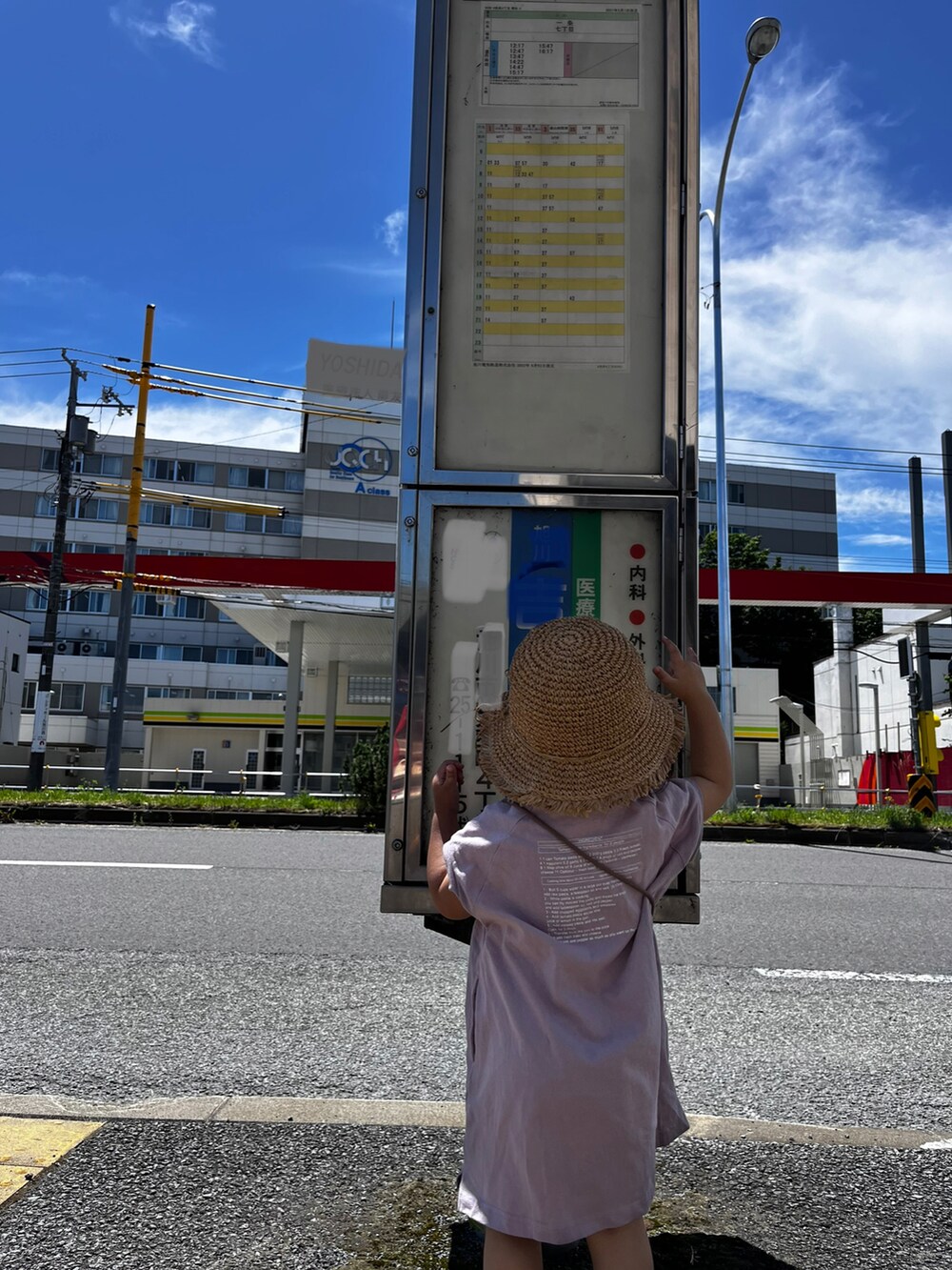パープル系のワンピース、ベージュ系のバッグ、ベージュ系の帽子を着用したキッズの夏コーディネートの2枚目の写真